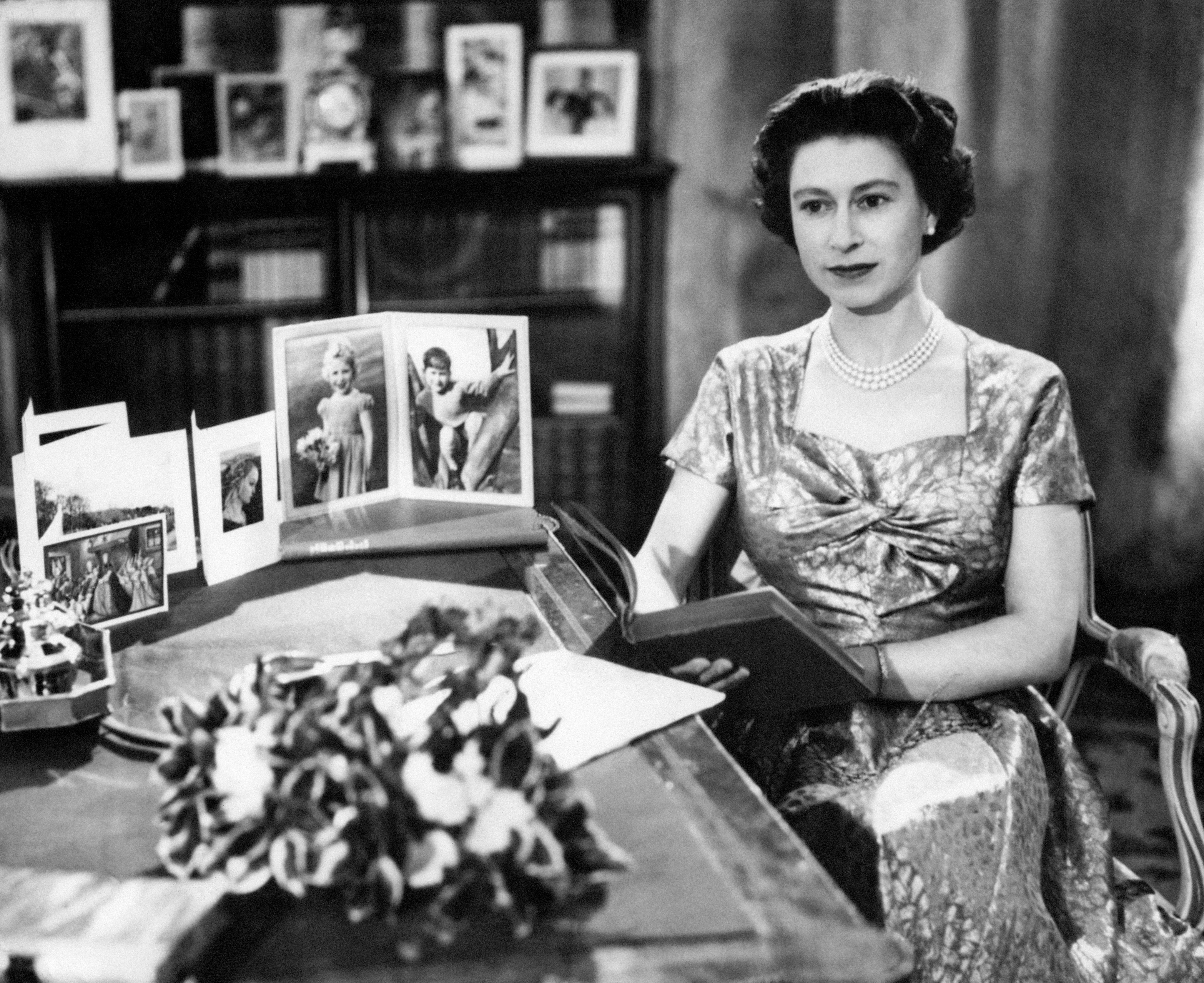 The Queen, in a gold lame dress, is seen in the Long Library at Sandringham shortly after making the traditional Christmas Day broadcast to the nation when it was televised for the first time