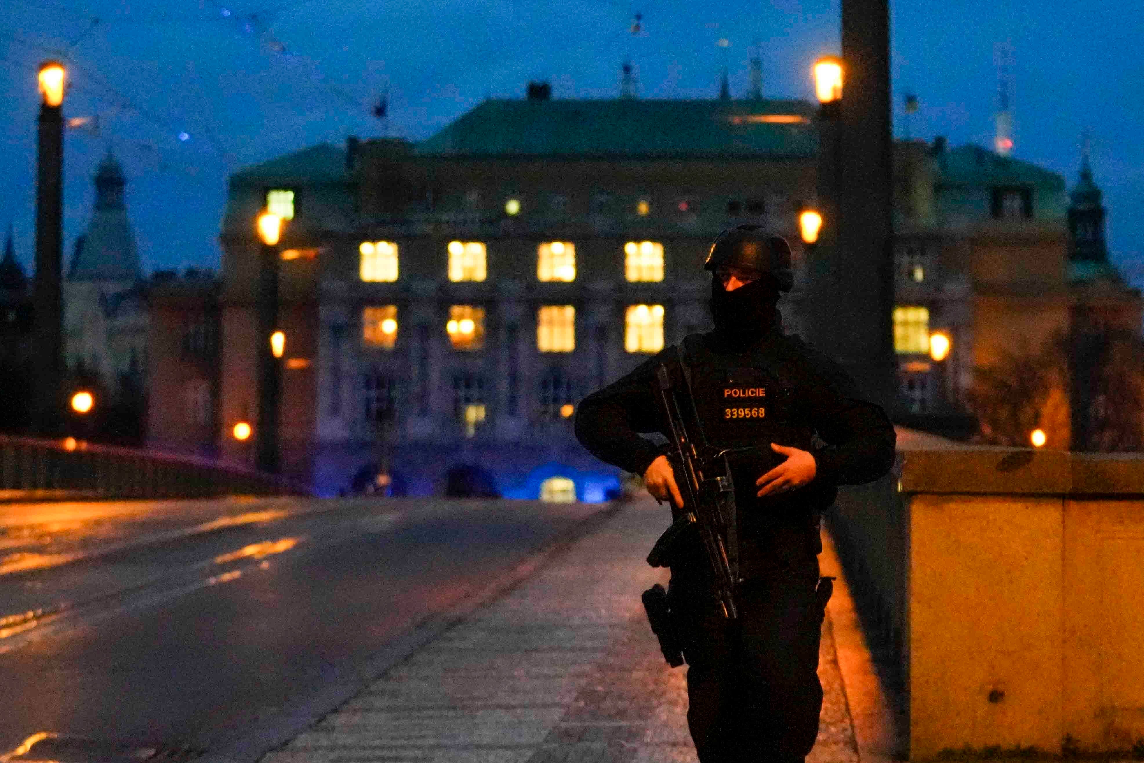 A police officer walks across a bridge over the Vltava river in downtown Prague, Czech Republic on Thursday