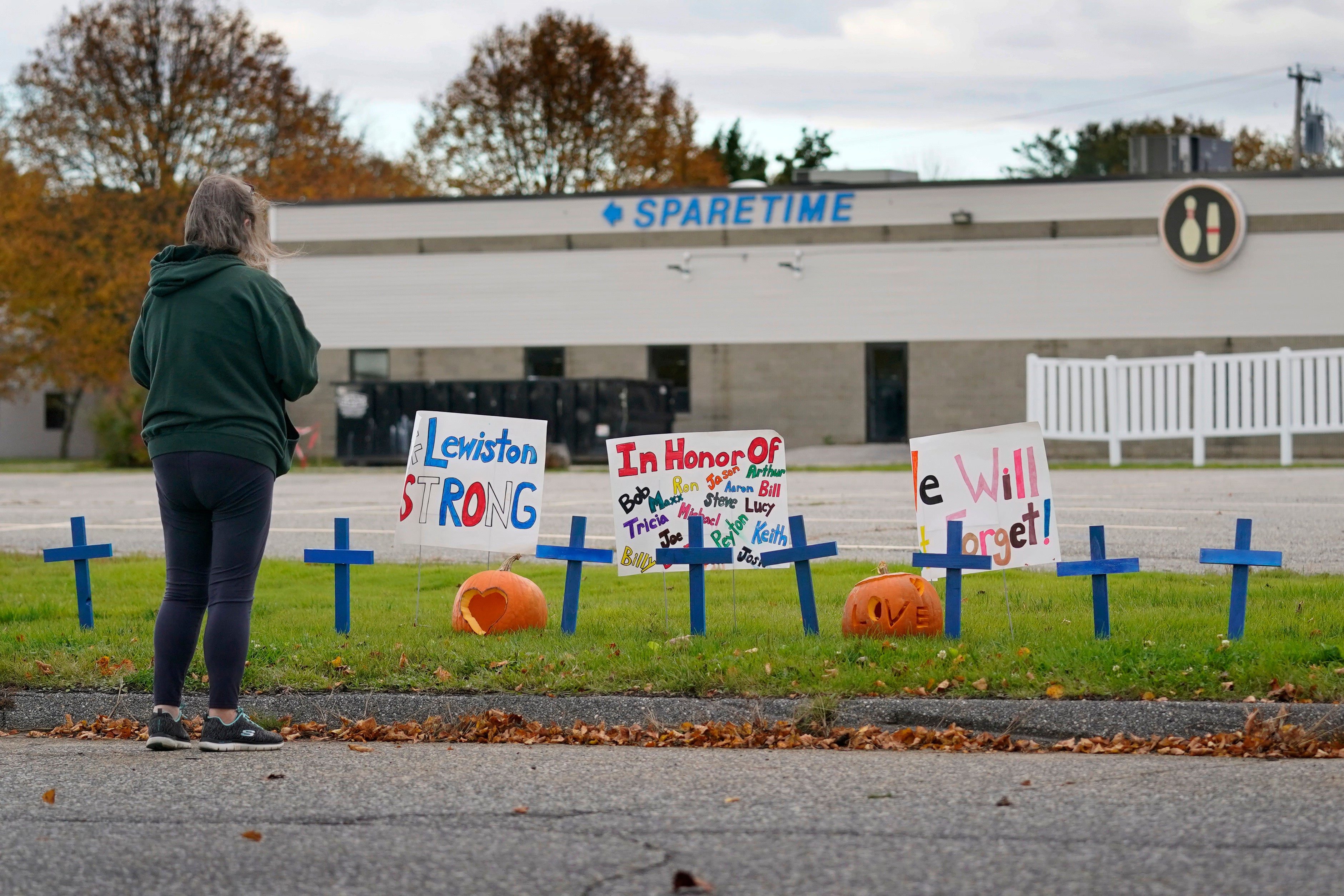 A woman visits a makeshift memorial outside Sparetime Bowling Alley, one of the site’s of the mass shooting