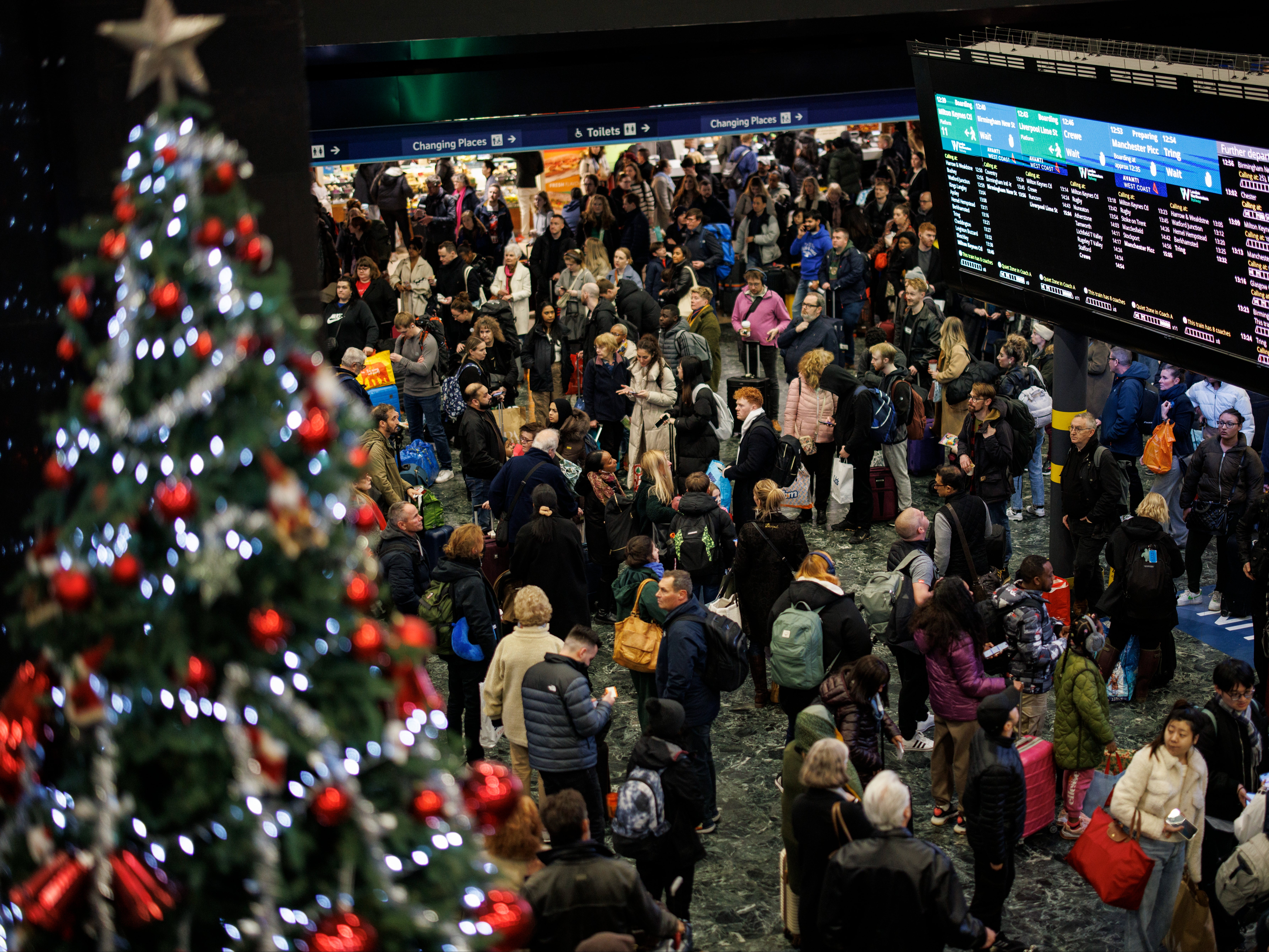 Passengers wait for train services to travel from London Euston on Friday as they make their Christmas getaway
