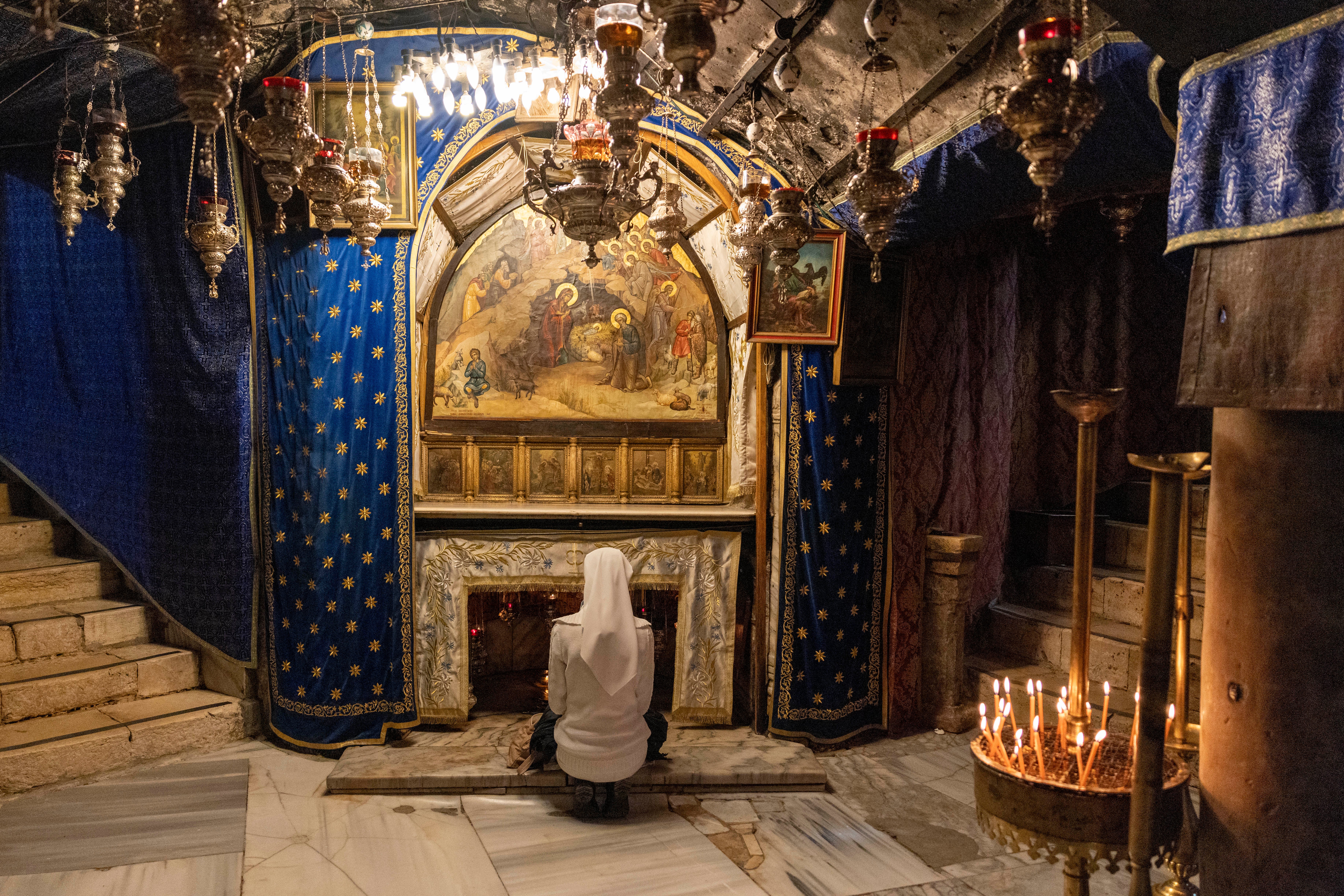 A nun prays in the grotto believed to be the spot where Jesus was born at the Church of the Nativity on 17 December in Bethlehem in the occupied West Bank.