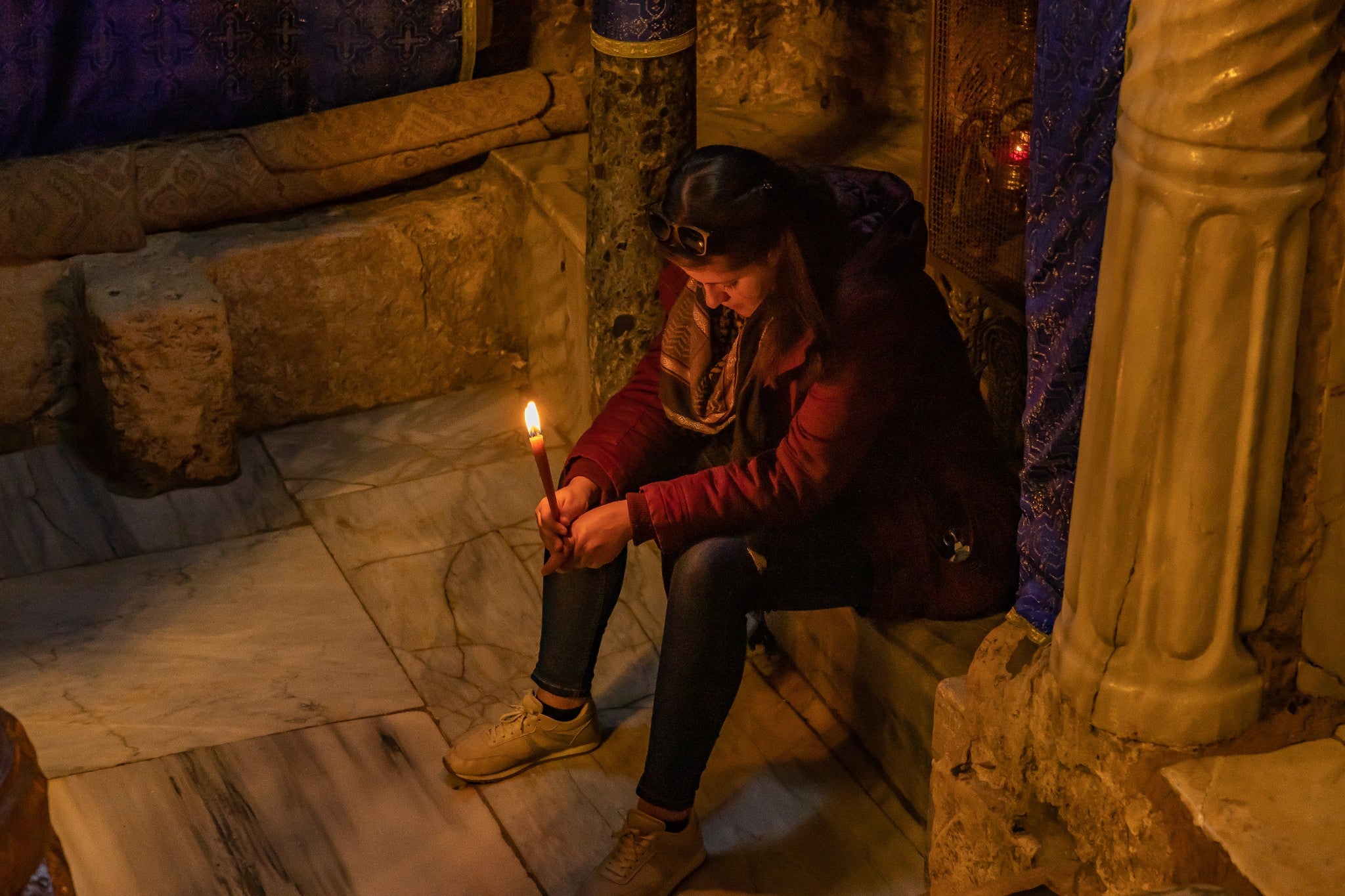 A worshipper prays for peace at the grotto inside the Church of the Nativity