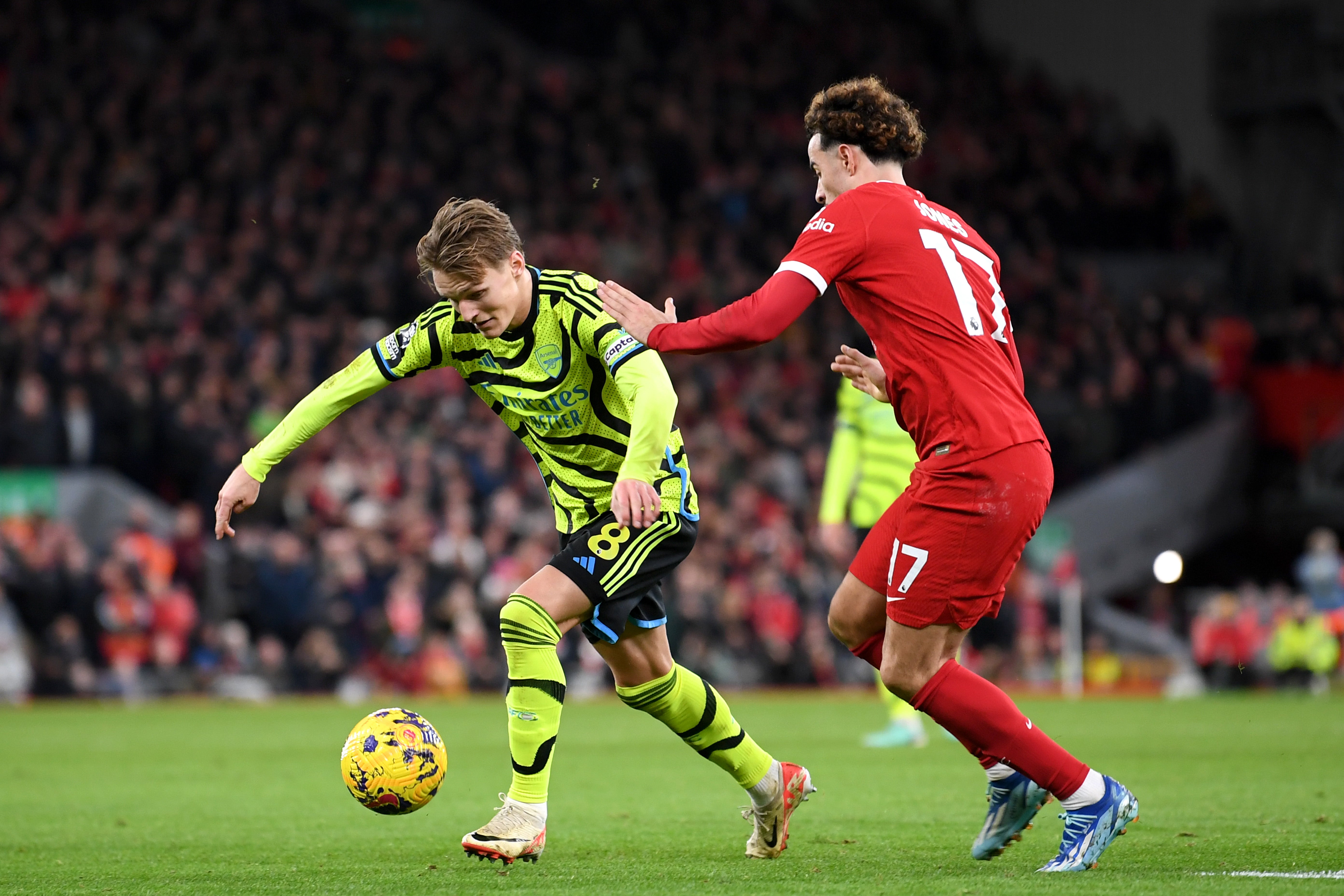 Martin Odegaard of Arsenal runs with the ball whilst under pressure from Curtis Jones of Liverpool