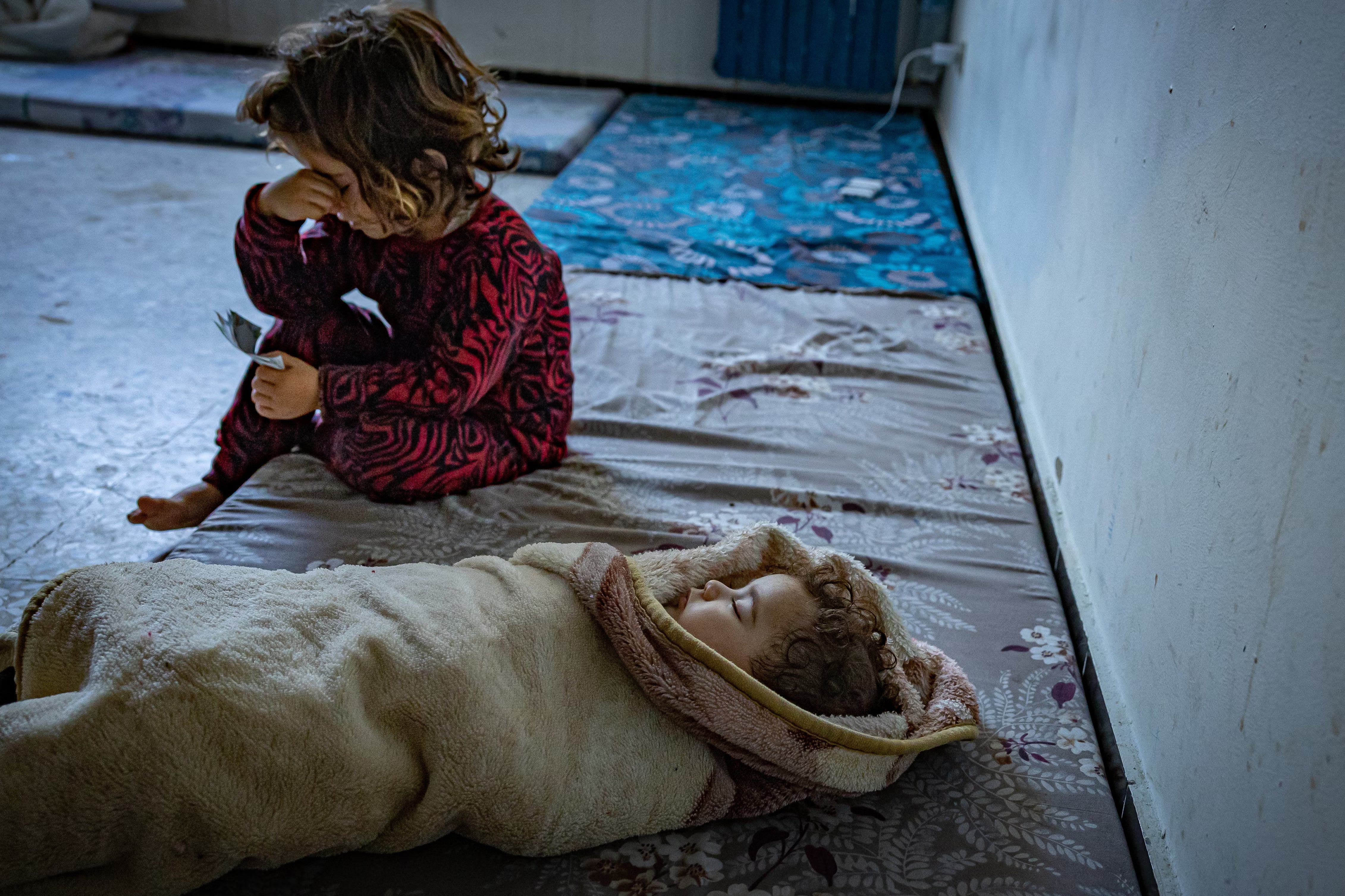 Asmaa’s five-month-old baby swaddled in a blanket, with another of her children at a school in Tyre. The family is among those who have had to flee the clashes at the Lebanon-Israeli border