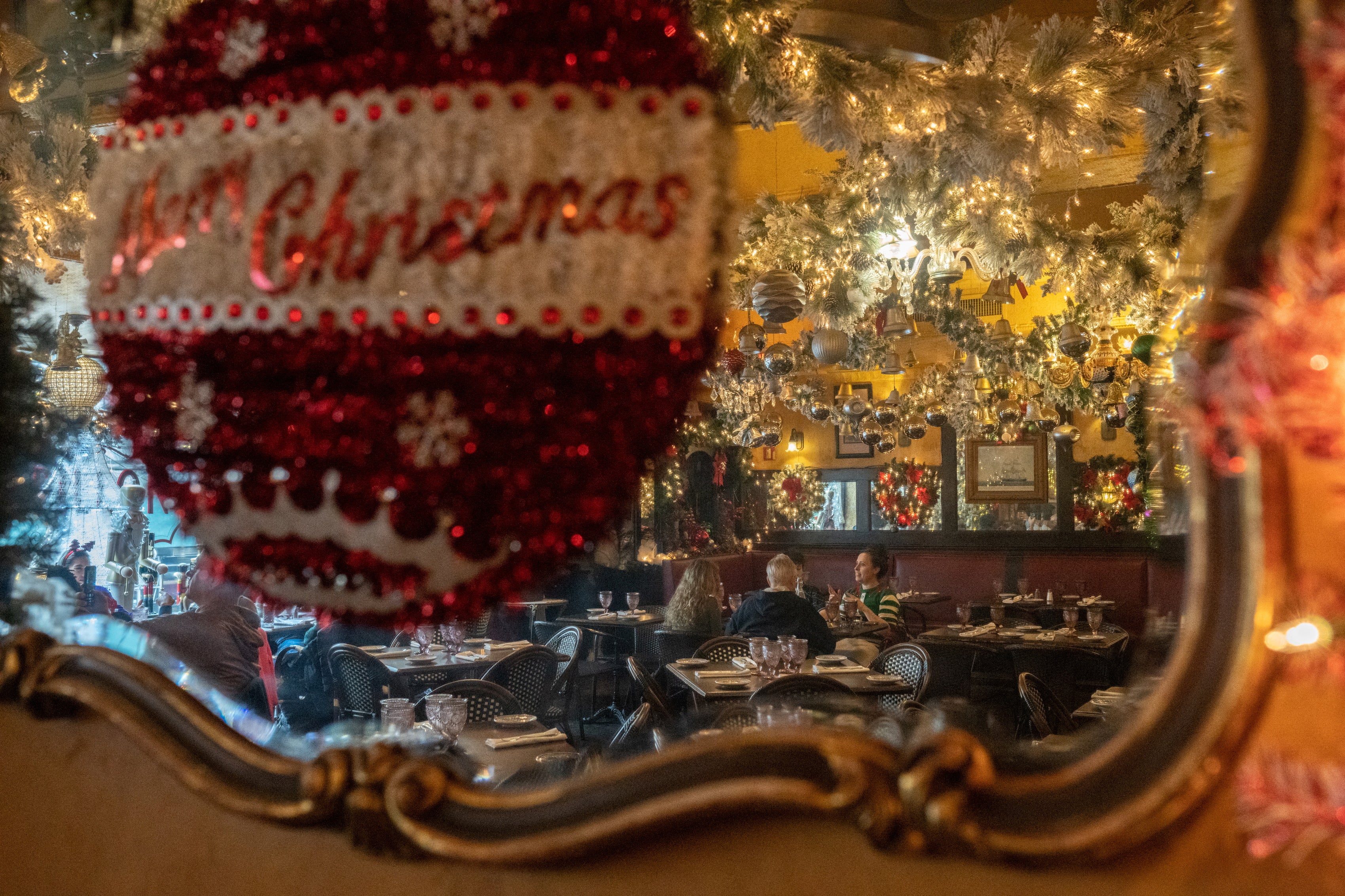 People reflected in a mirror at a restaurant on Christmas Eve in the US this year