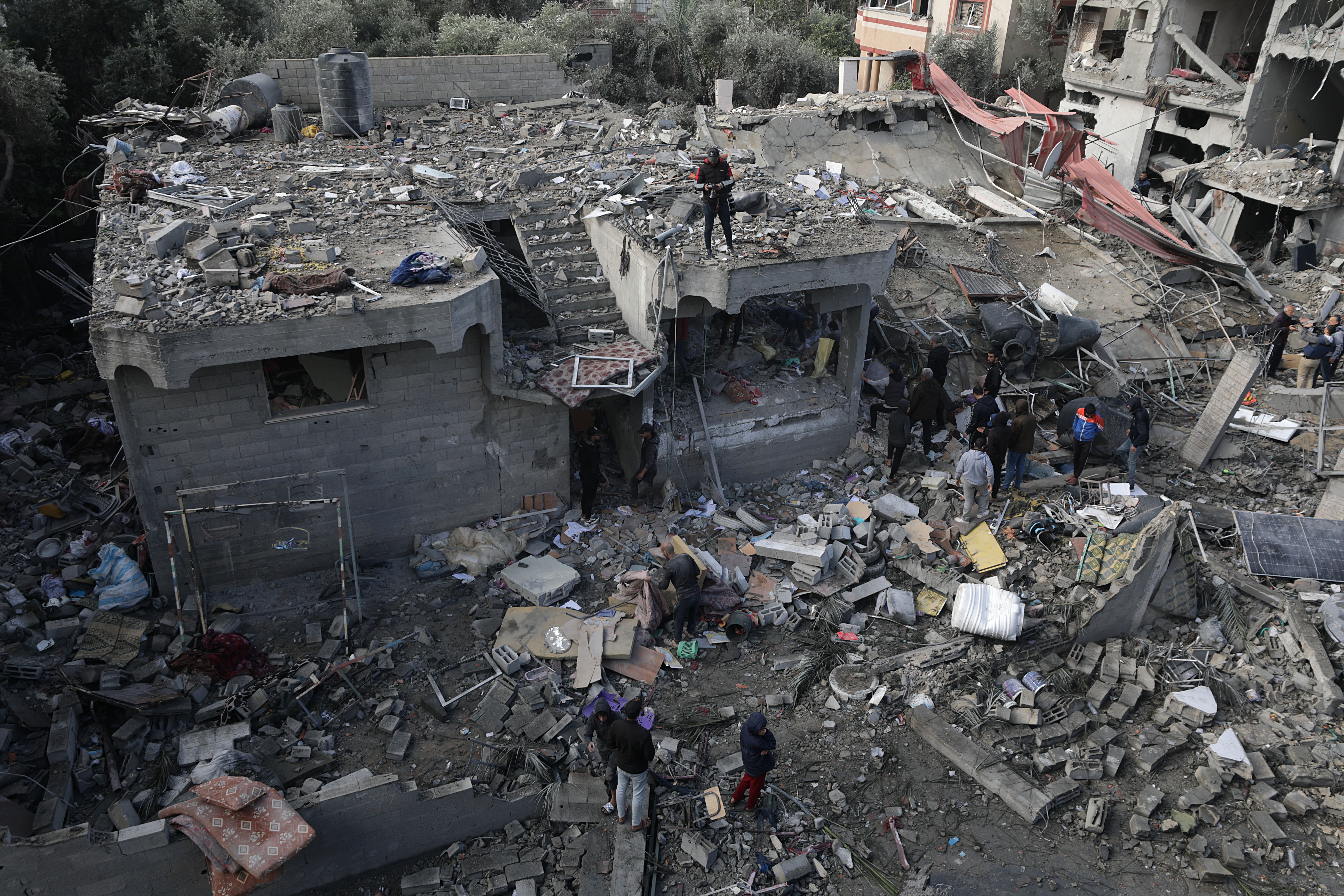Palestinians search for bodies and survivors in the rubble of the destroyed house of the Manasra family following an Israeli airstrike in the southern Gaza Strip on Christmas Day