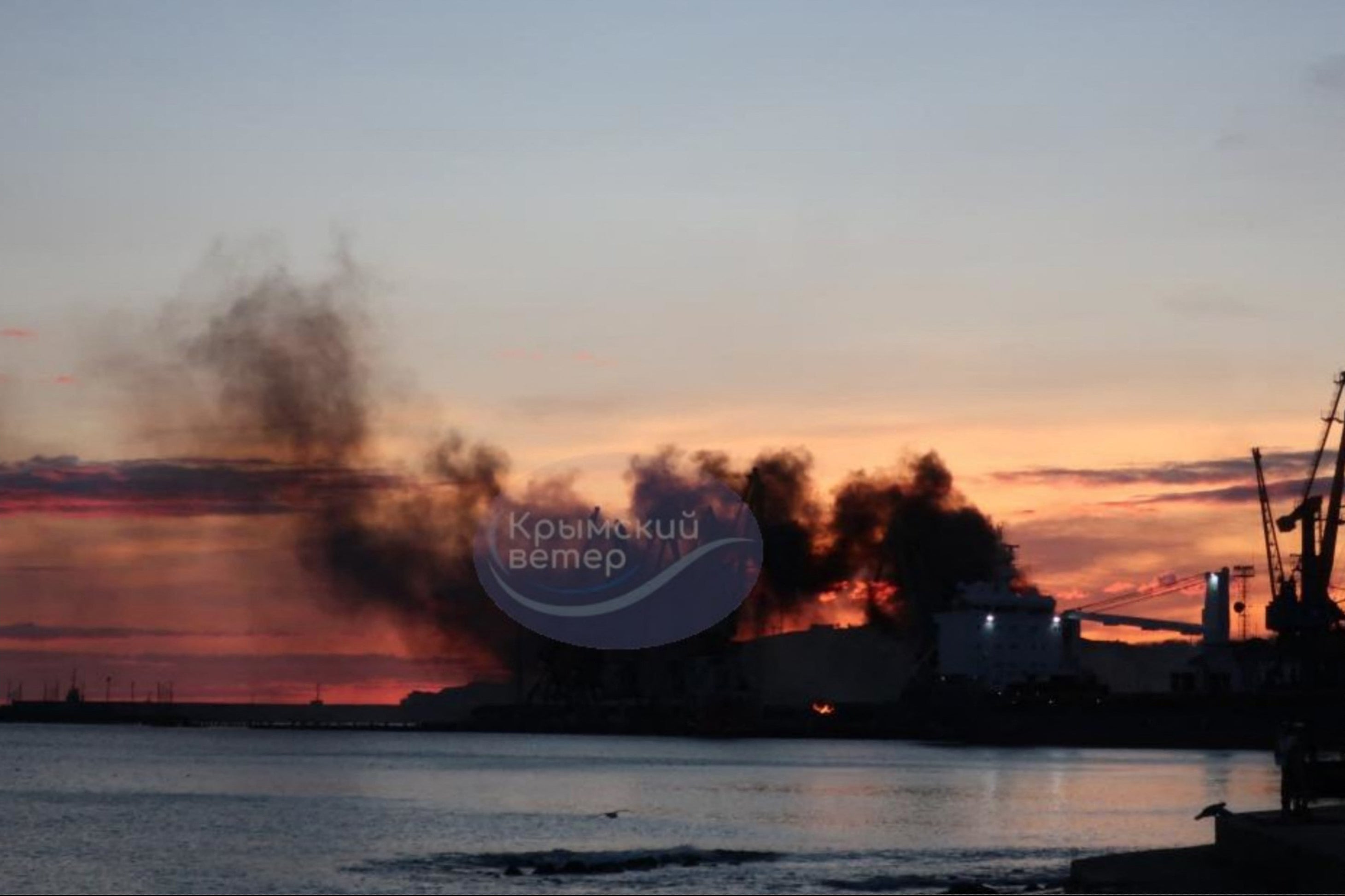 Smoke is seen rising above a damaged warship following a Ukrainian attack in the Russian-occupied Black Sea port