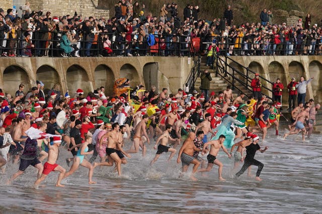 Swimmers take part in the Folkestone Lions’ Boxing Day Dip at Sunny Sands Beach in Folkestone, Kent (Gareth Fuller/PA)