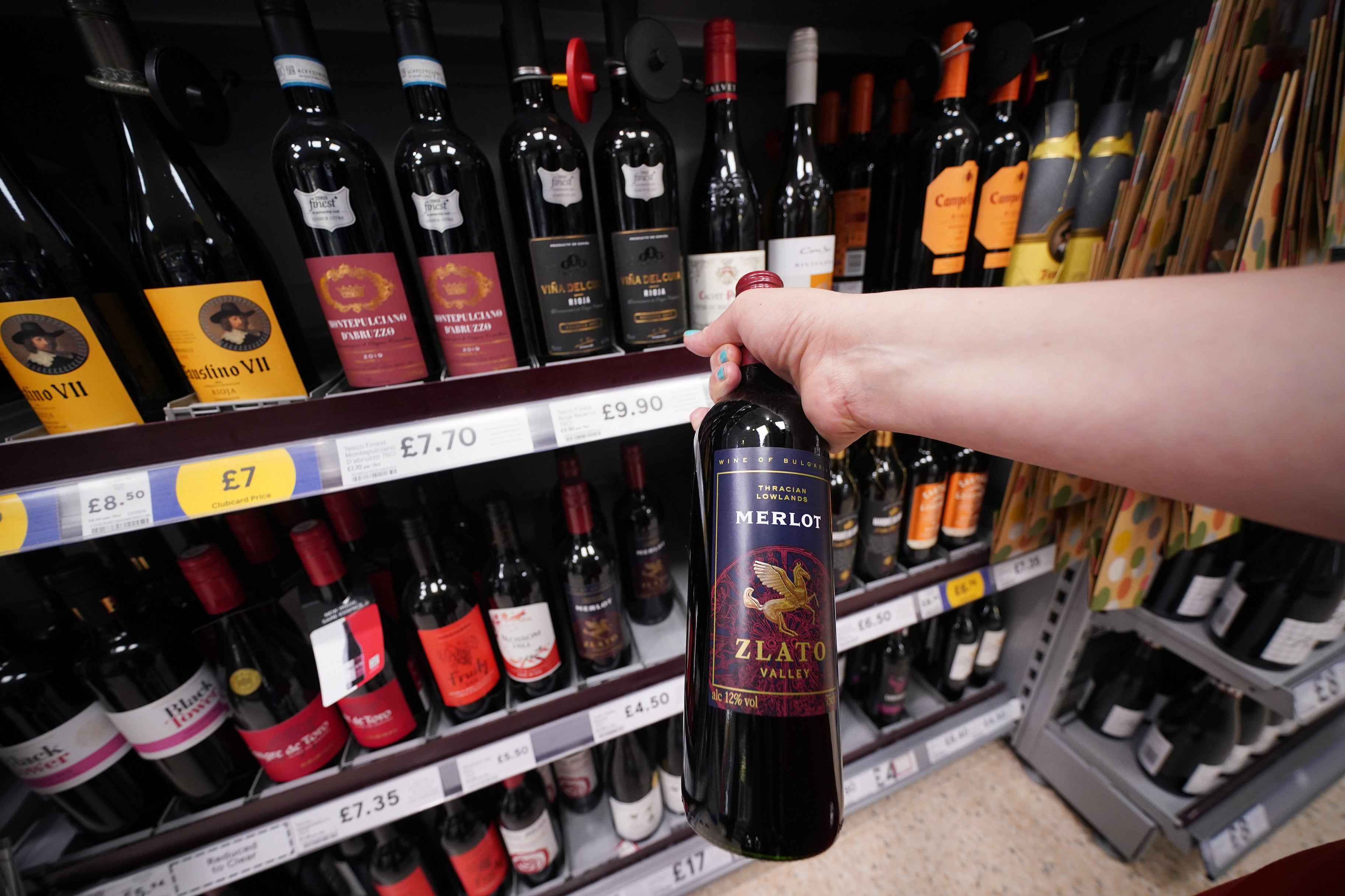 A shopper looking at wine in a Tesco supermarket in London