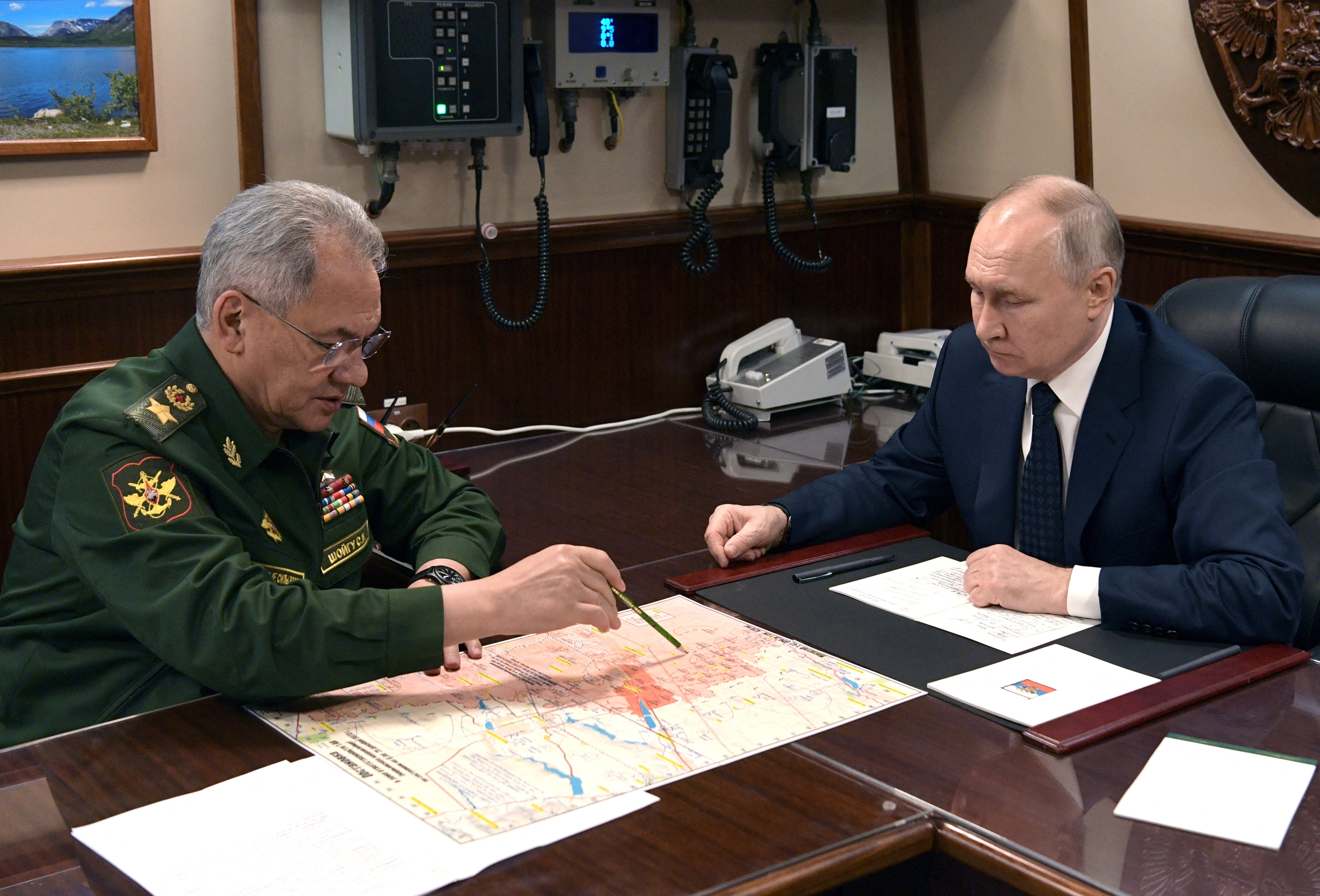 Russia’s President Vladimir Putin listens to Defence Minister Sergei Shoigu during a meeting after a flag-raising ceremony for the Admiral Golovko frigate joining the Russian Navy Fleet at a shipyard in Saint Petersburg