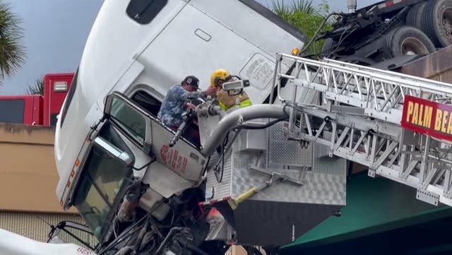 <p>Watch moment driver rescued from dangling truck cab over busy highway.</p>