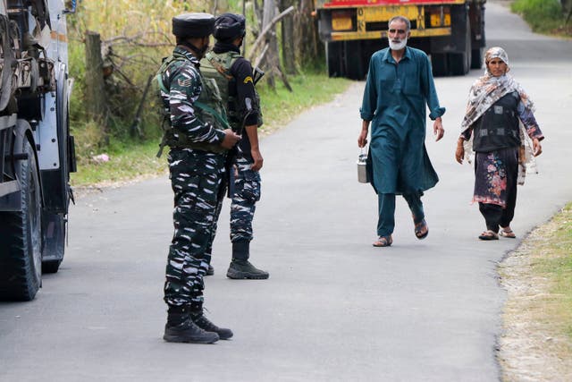 <p>File: Indian army soldiers stand guard as Kashmiri residents walk past</p>