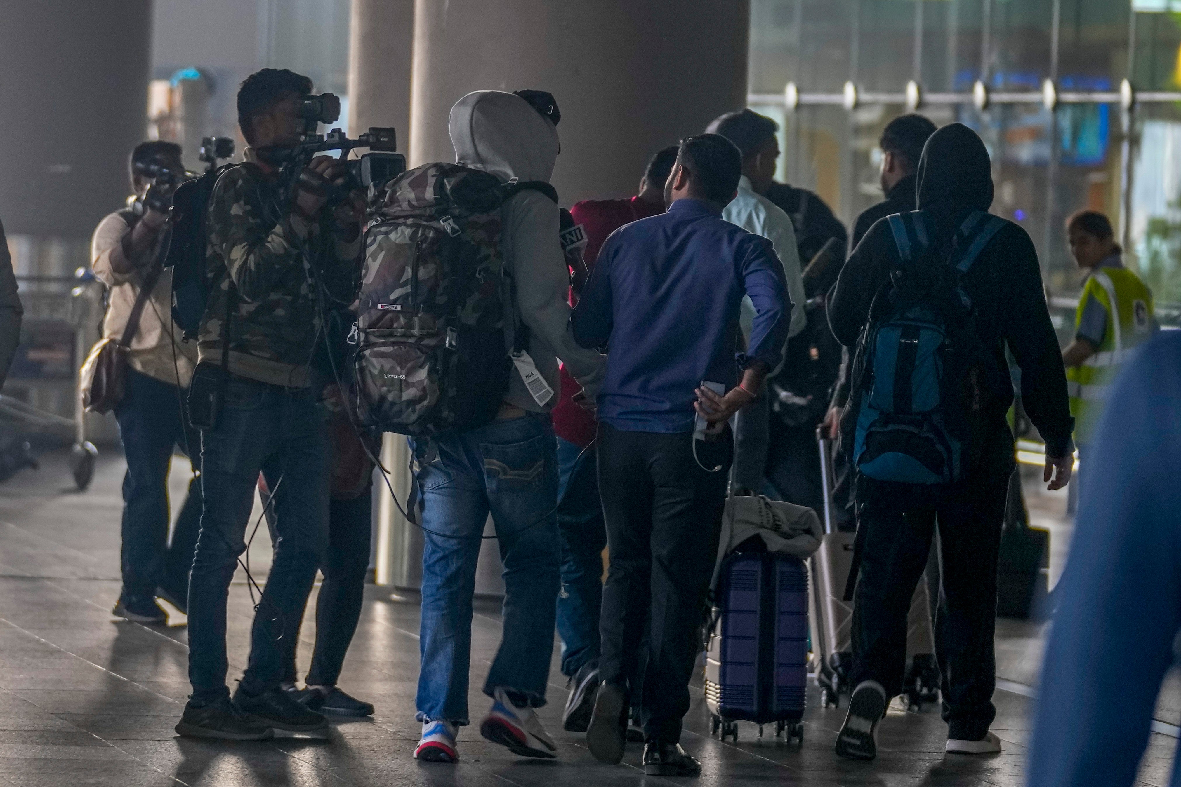 <p>Journalists try to interview Indian passengers, who arrived in an unmarked Legend Airlines A340 from Vatry Airport</p>