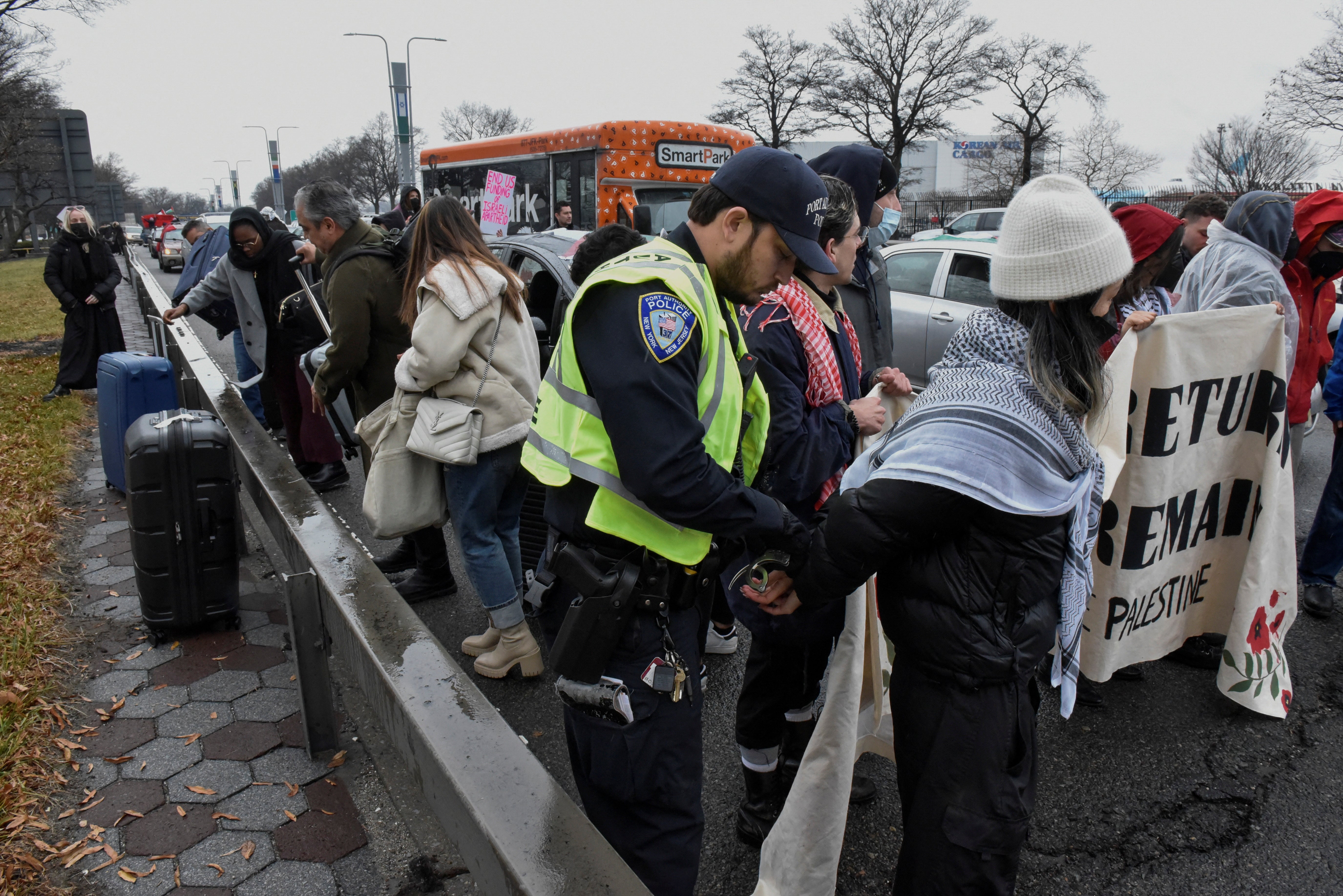 Pro-Palestinian demonstrators are detained by Port Authority police after blocking traffic on the road that leads to John F Kennedy airport on 27 December