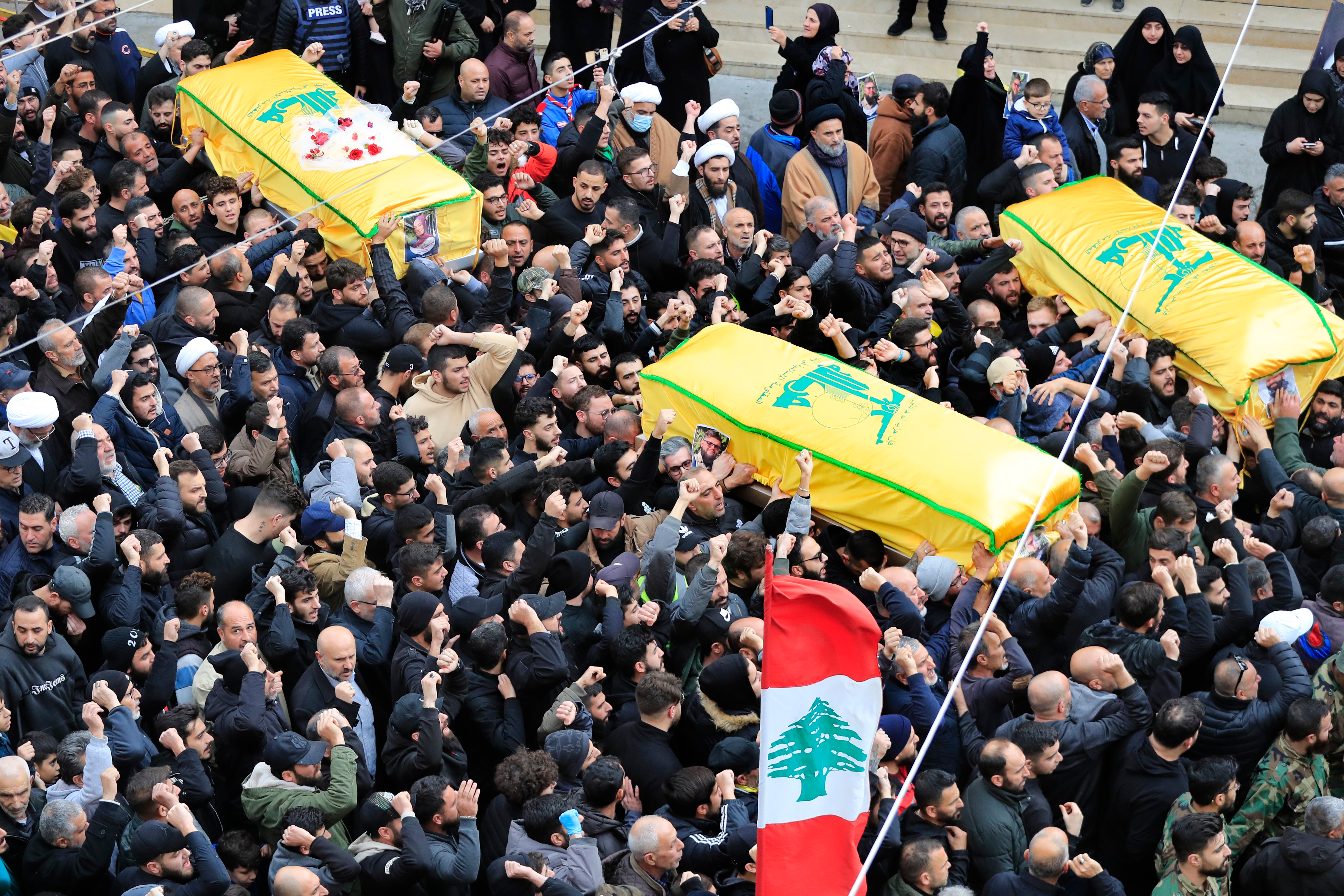 Mourners carry the coffins of a Hezbollah fighter and two civilians killed by an Israeli airstrike this week