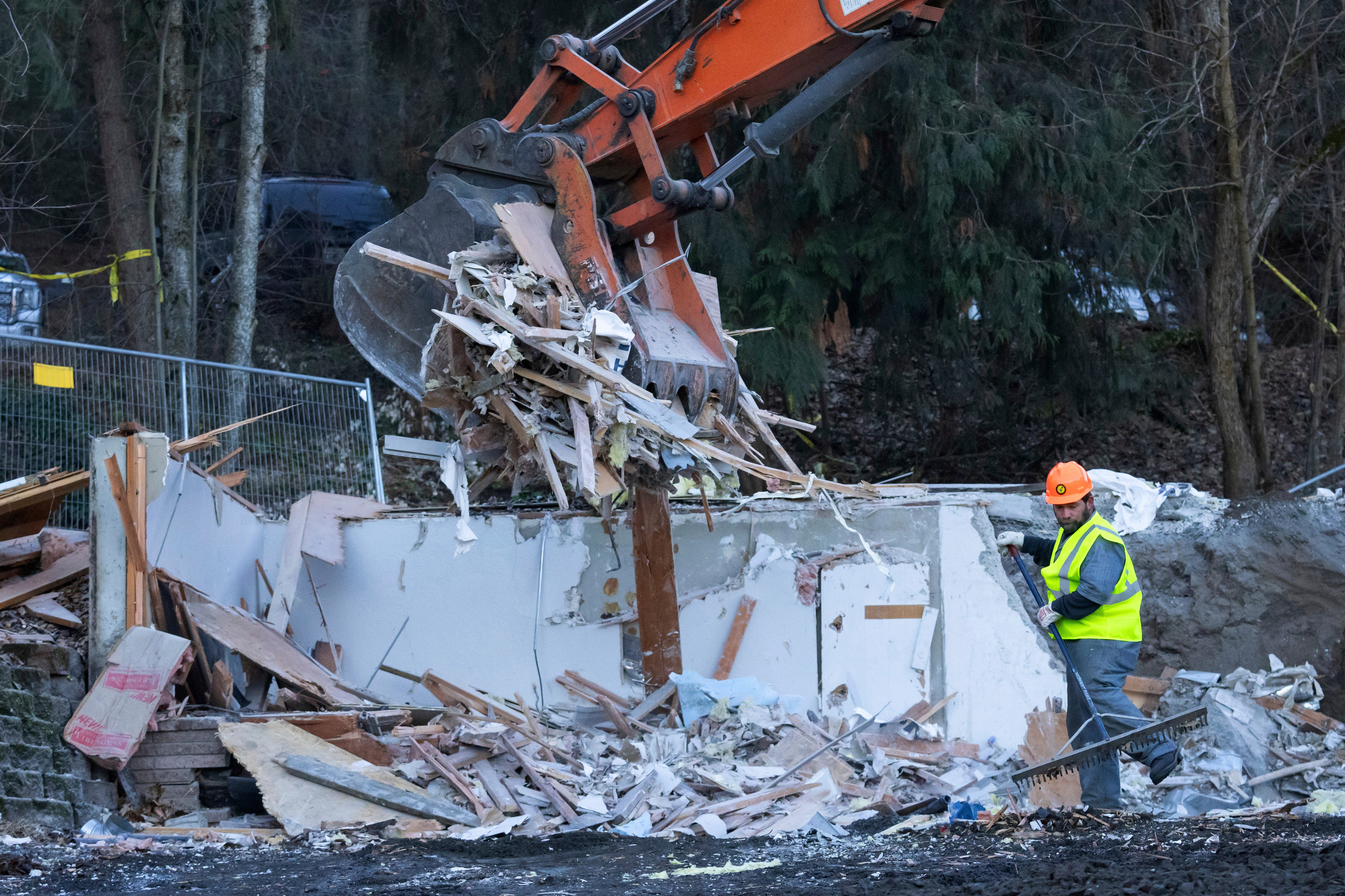 A worker rakes debris during a pause in the use of heavy equipment to demolish the house where four University of Idaho students were killed in 2022 on Thursday, Dec. 28, 2023, in Moscow, Idaho