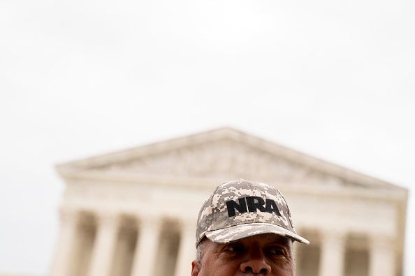 A person wears an NRA hat in front of the US Supreme Court in Washington, DC, on 21 June 2022.