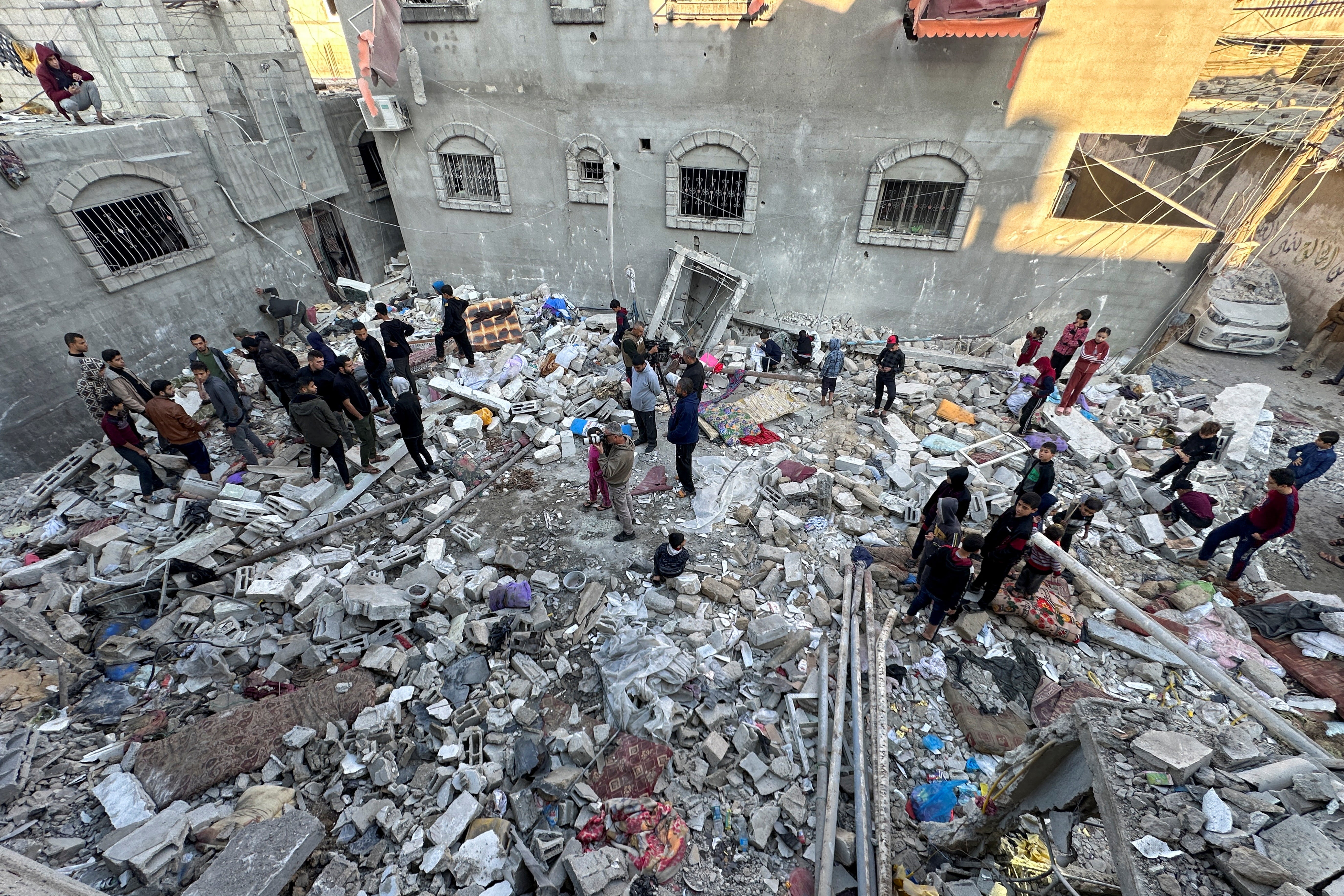 Palestinians gather at the site of an Israeli strike on a house in Gaza, amid the ongoing conflict