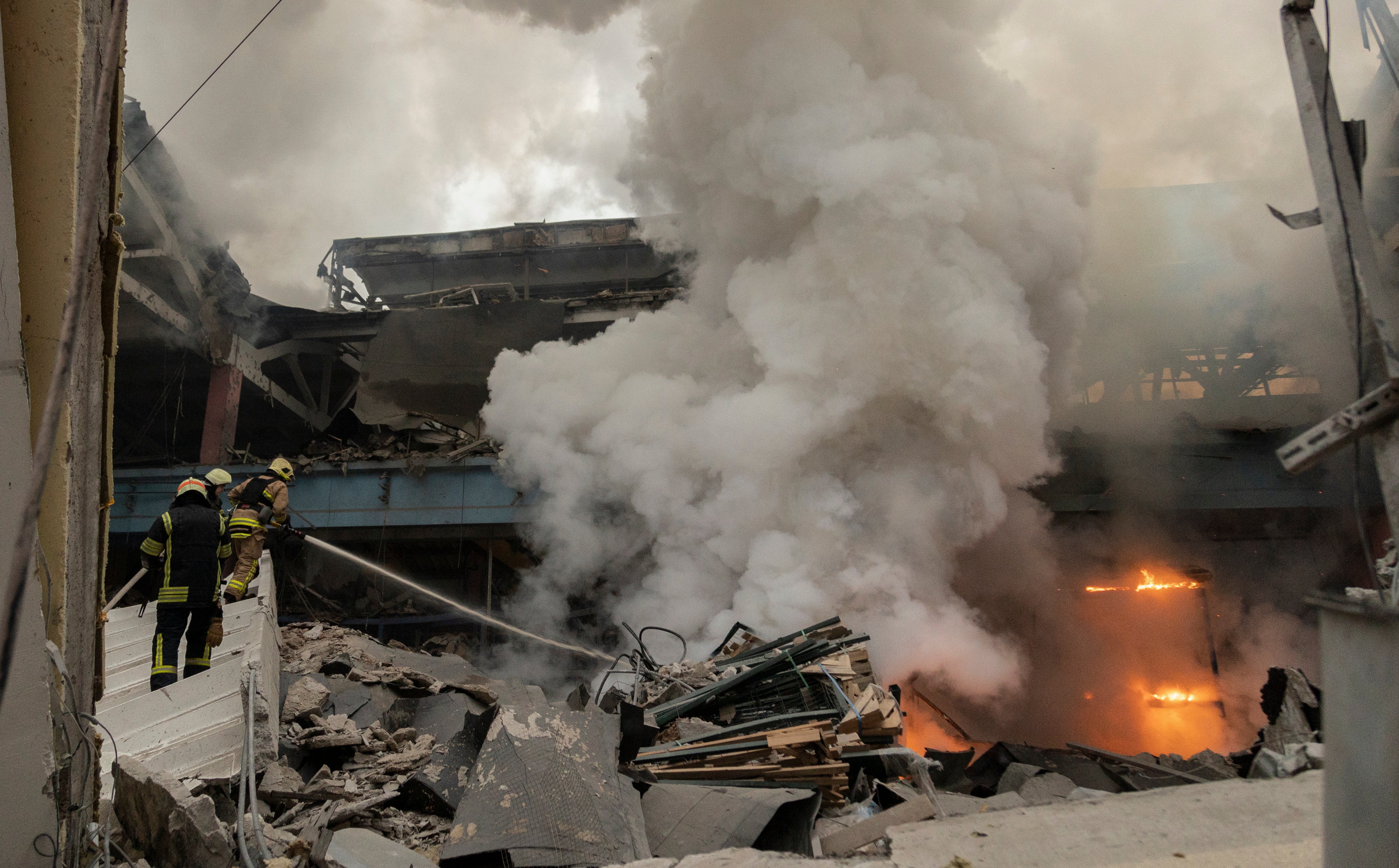 Ukrainian rescuers work at the site of a rocket attack on a civilian factory in Kharkiv, northeastern Ukraine