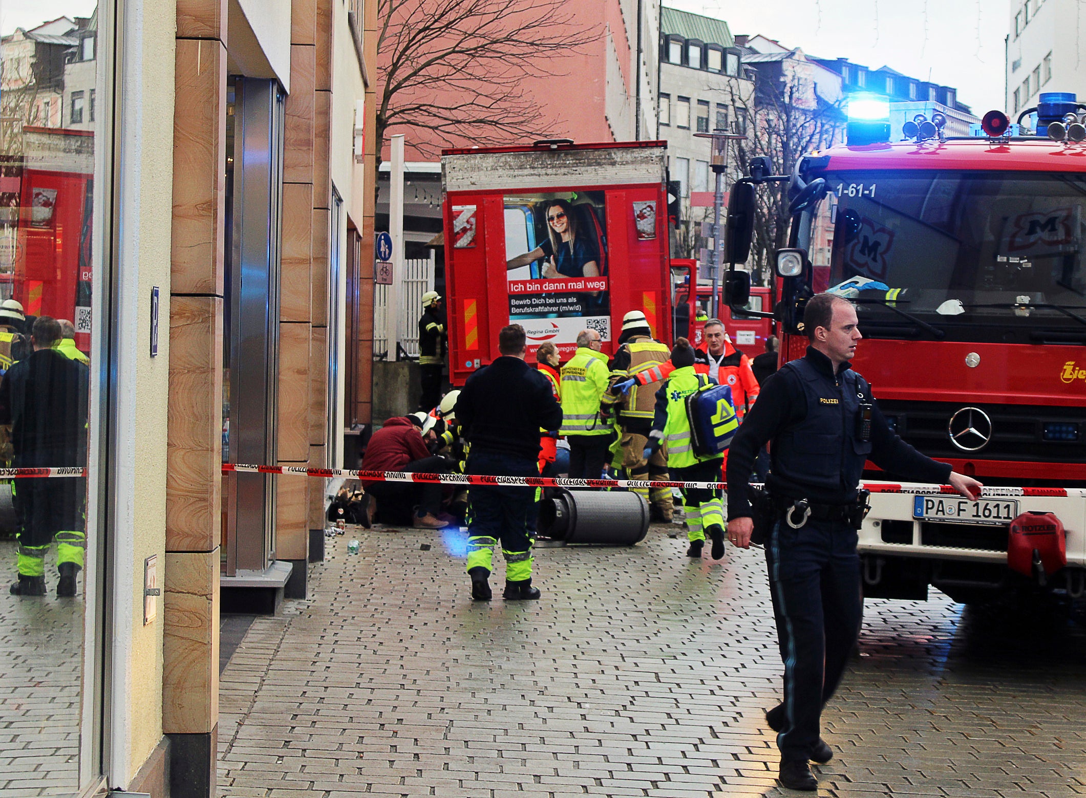 Fire and rescue services stand at the scene of a car accident in the city center in Passau