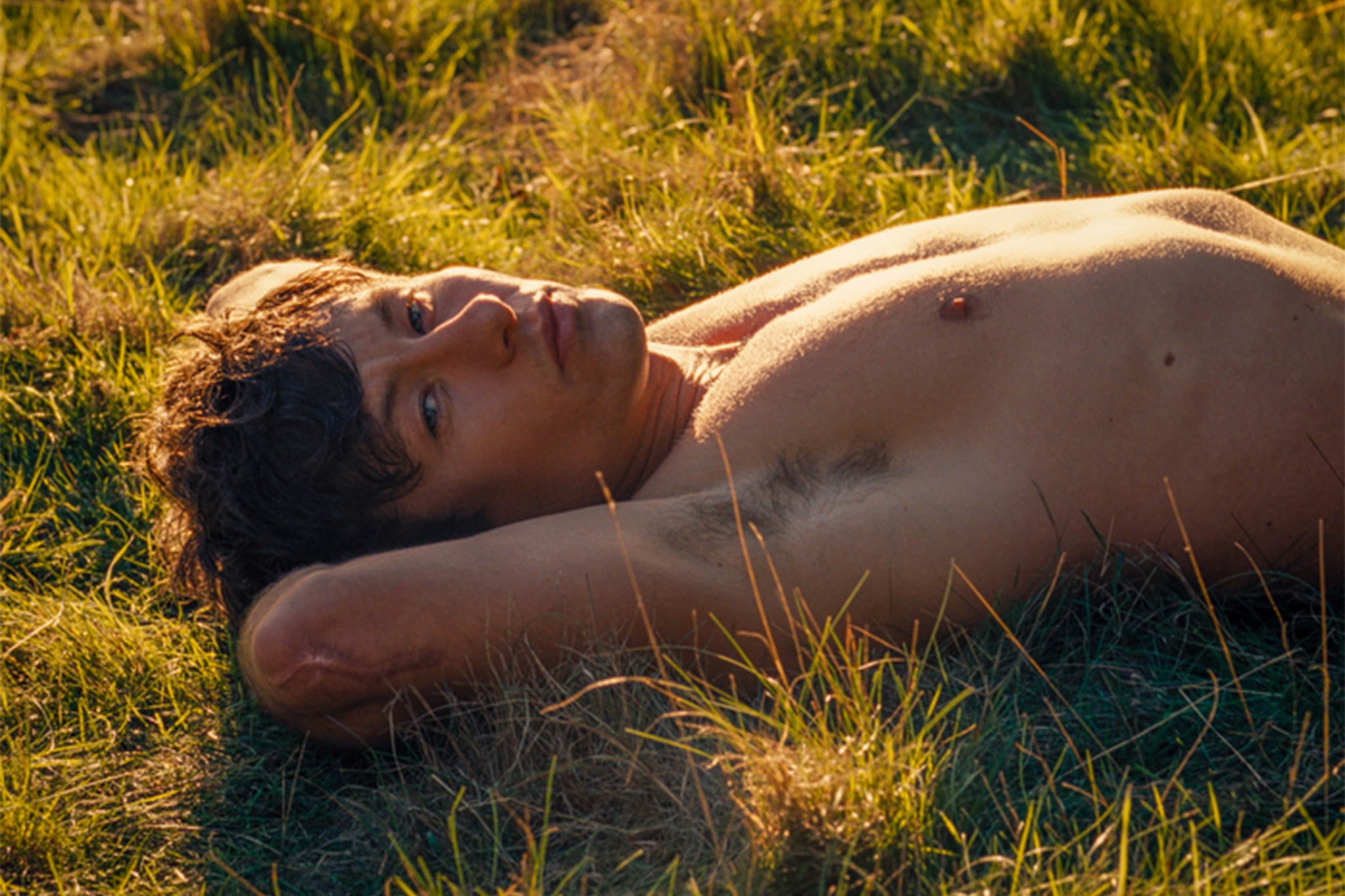 Barry Keoghan’s Oliver Quick lounges on the grass in ‘Saltburn’