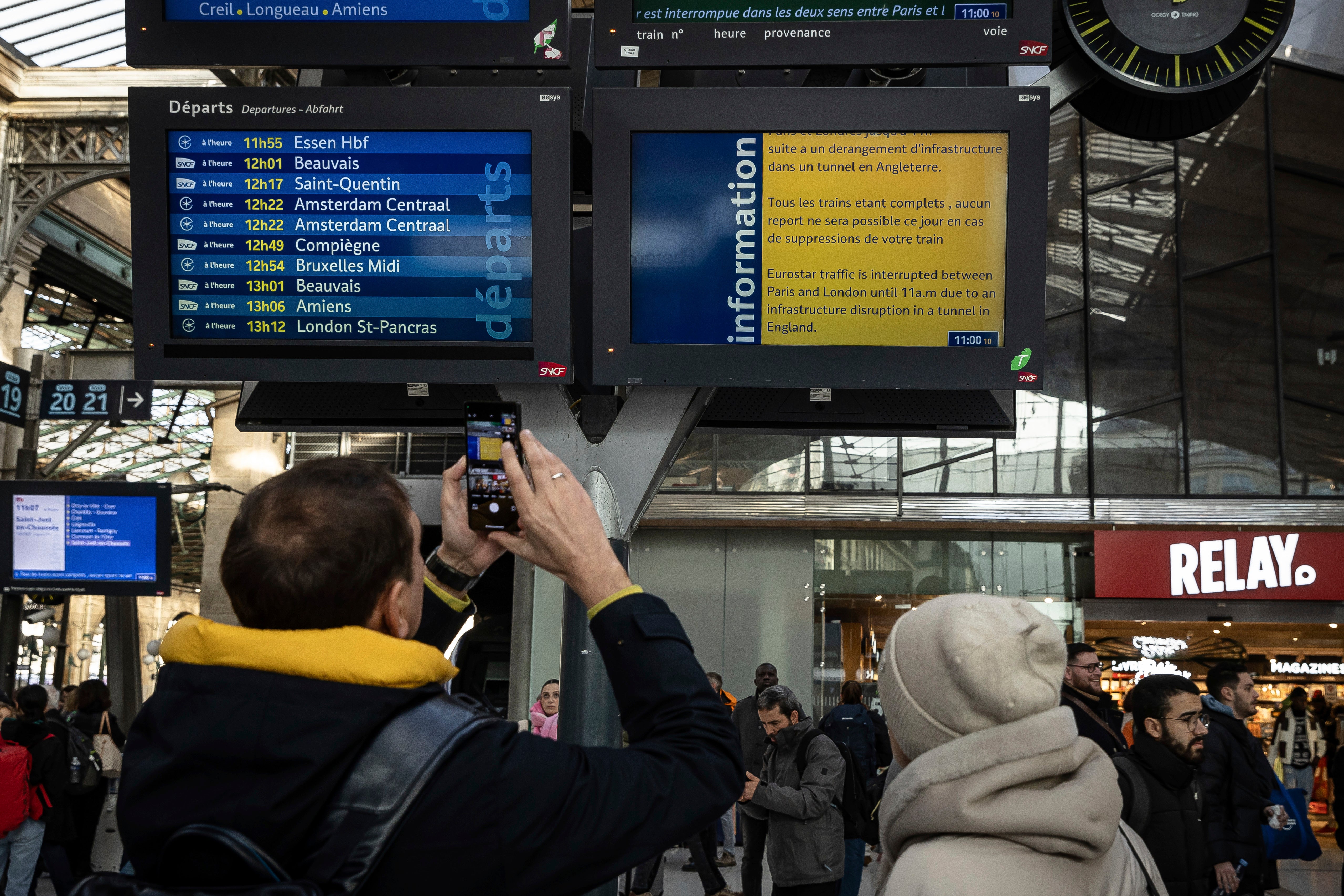 Passengers stare at a board of cancellations at the Gare du Nord