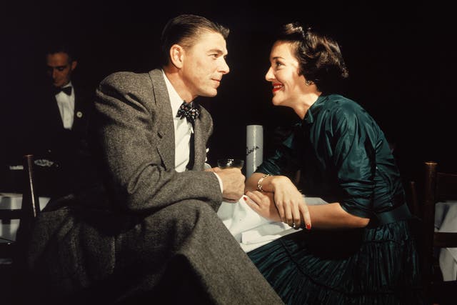 <p>Ronald Reagan and his wife Nancy Reagan gaze at one another across a table, circa 1952</p>
