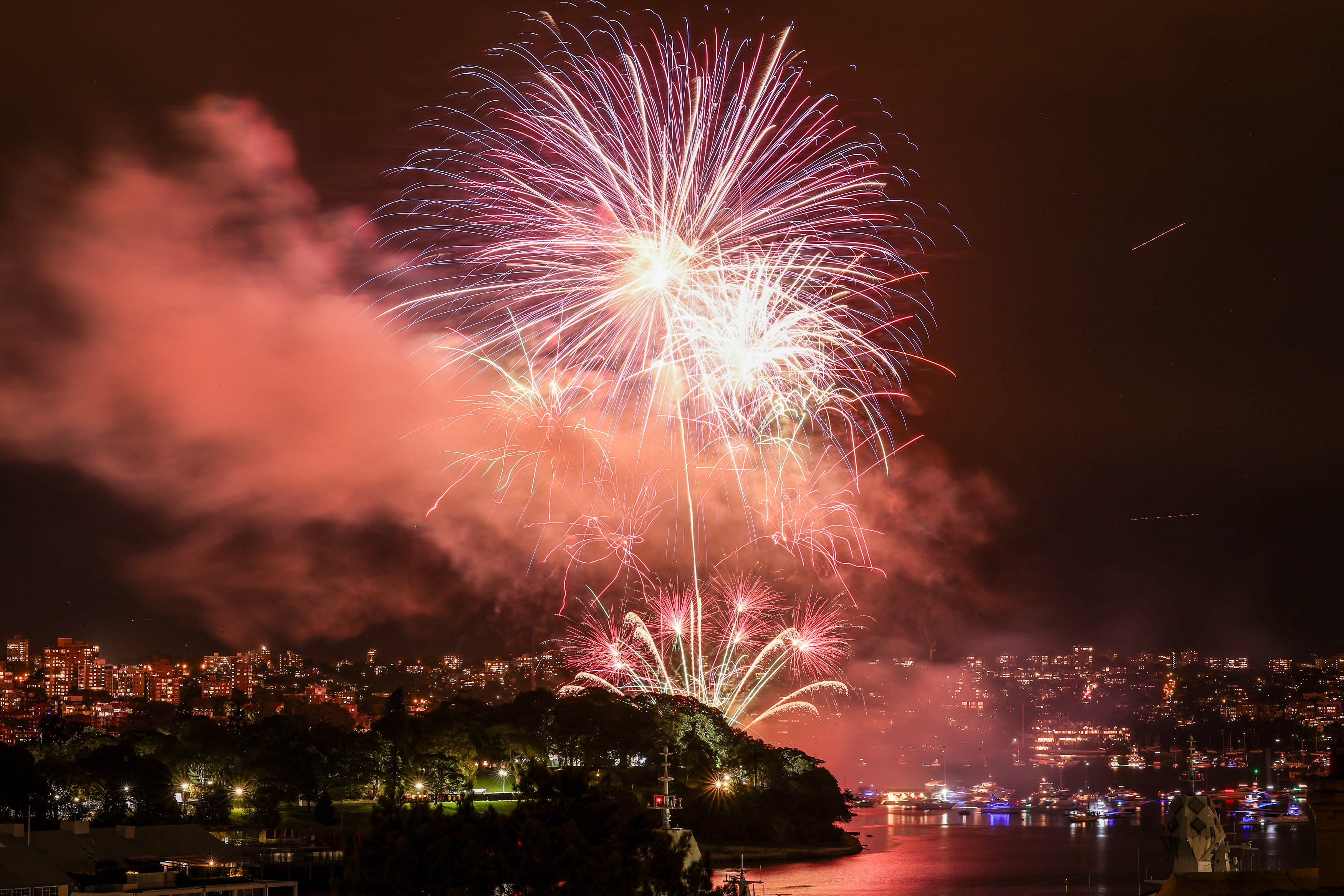 The 9pm "family fireworks" explode over boats on Sydney Harbour during New Year's Eve celebrations in Sydney