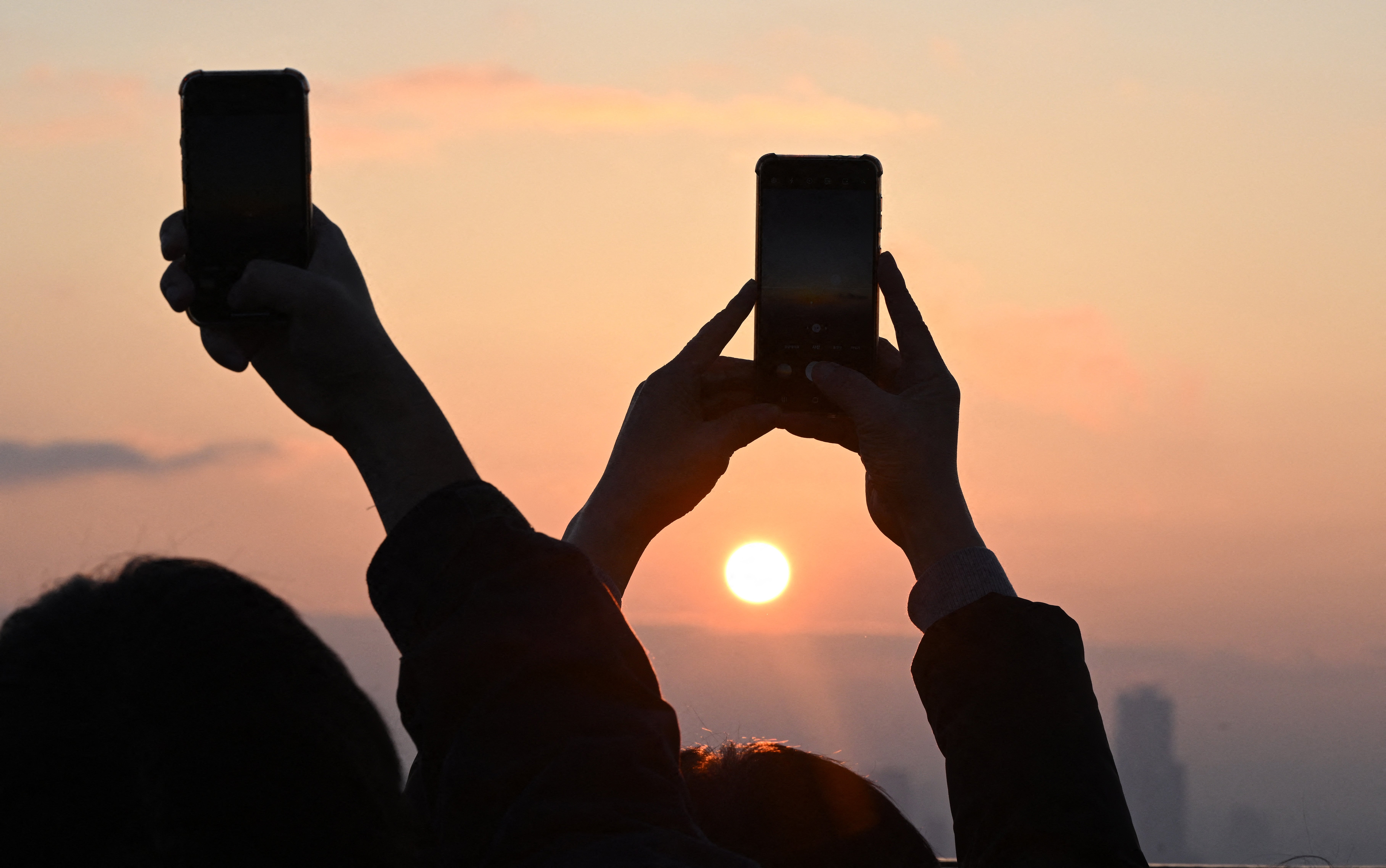 <p>People take pictures as they observe the last sunset of the year on a viewing deck at Namsan tower in Seoul </p>