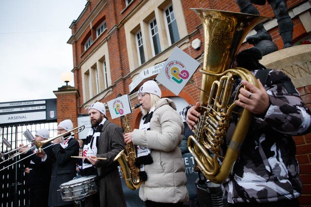 <p>A brass band plays outside Craven Cottage stadium ahead of the English Premier League  match between Fulham FC and Arsenal FC</p>