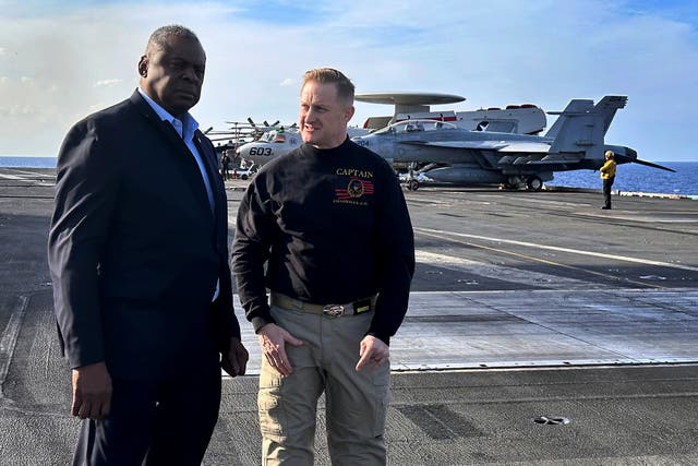 <p>Defence Secretary Lloyd Austin, left, talks with the commanding officer of the USS Gerald R Ford, Navy Captain Rick Burgess</p>