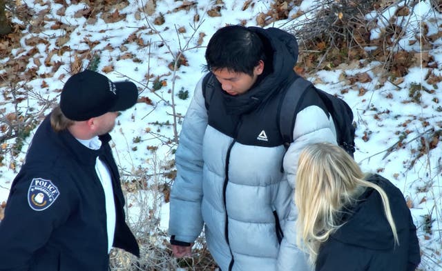 <p>Authorities speaking to Kai Zhuang near the site where he was found in the mountains near Brigham City, Utah</p>