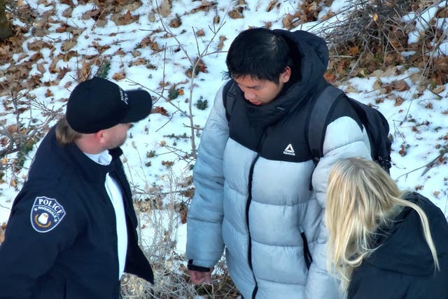 <p>Authorities speaking to Kai Zhuang near the site where he was found in the mountains near Brigham City, Utah</p>
