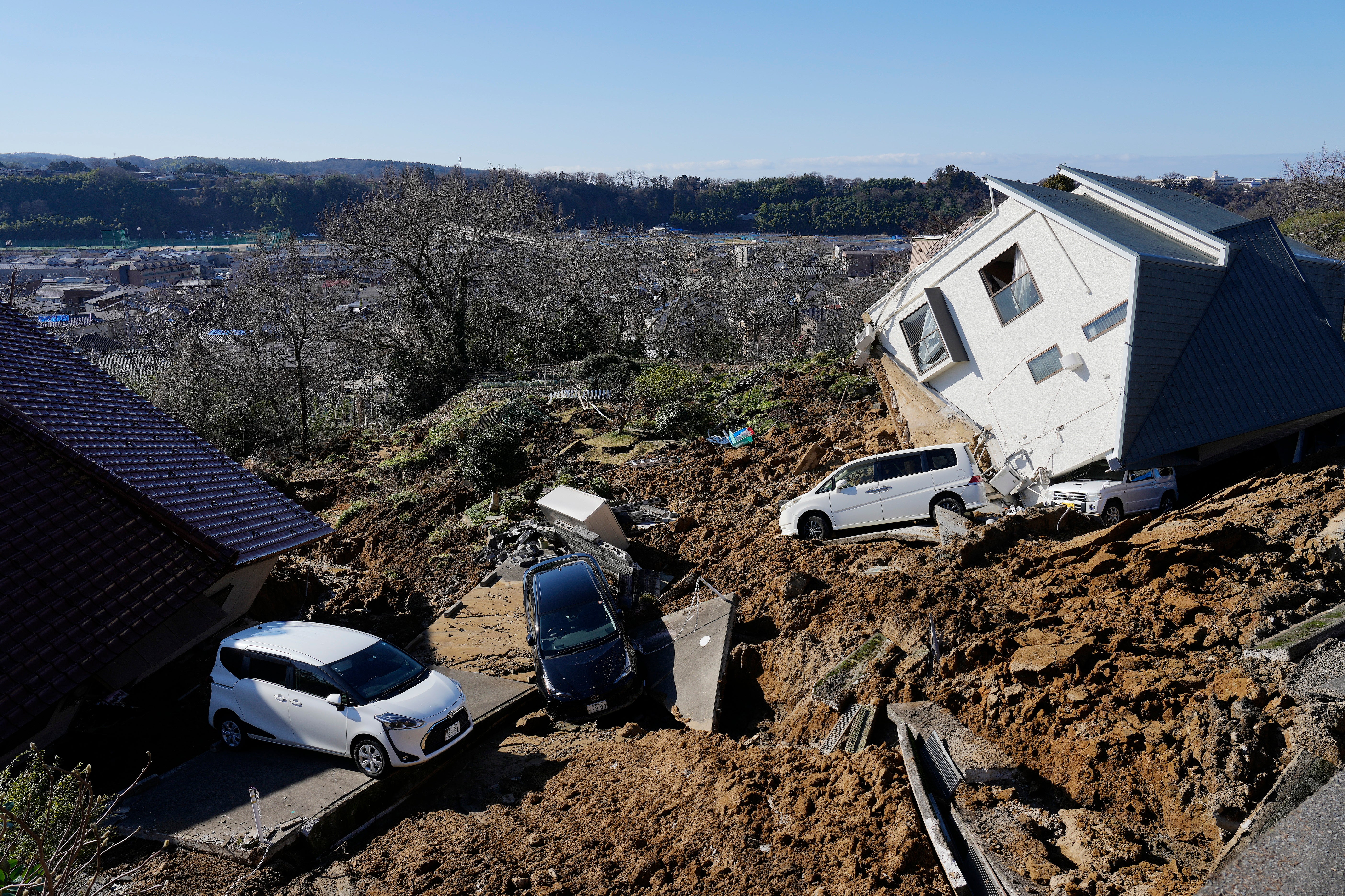 A view of a damaged home and vehicles following a strong earthquake in Kanazawa, Ishikawa Prefecture