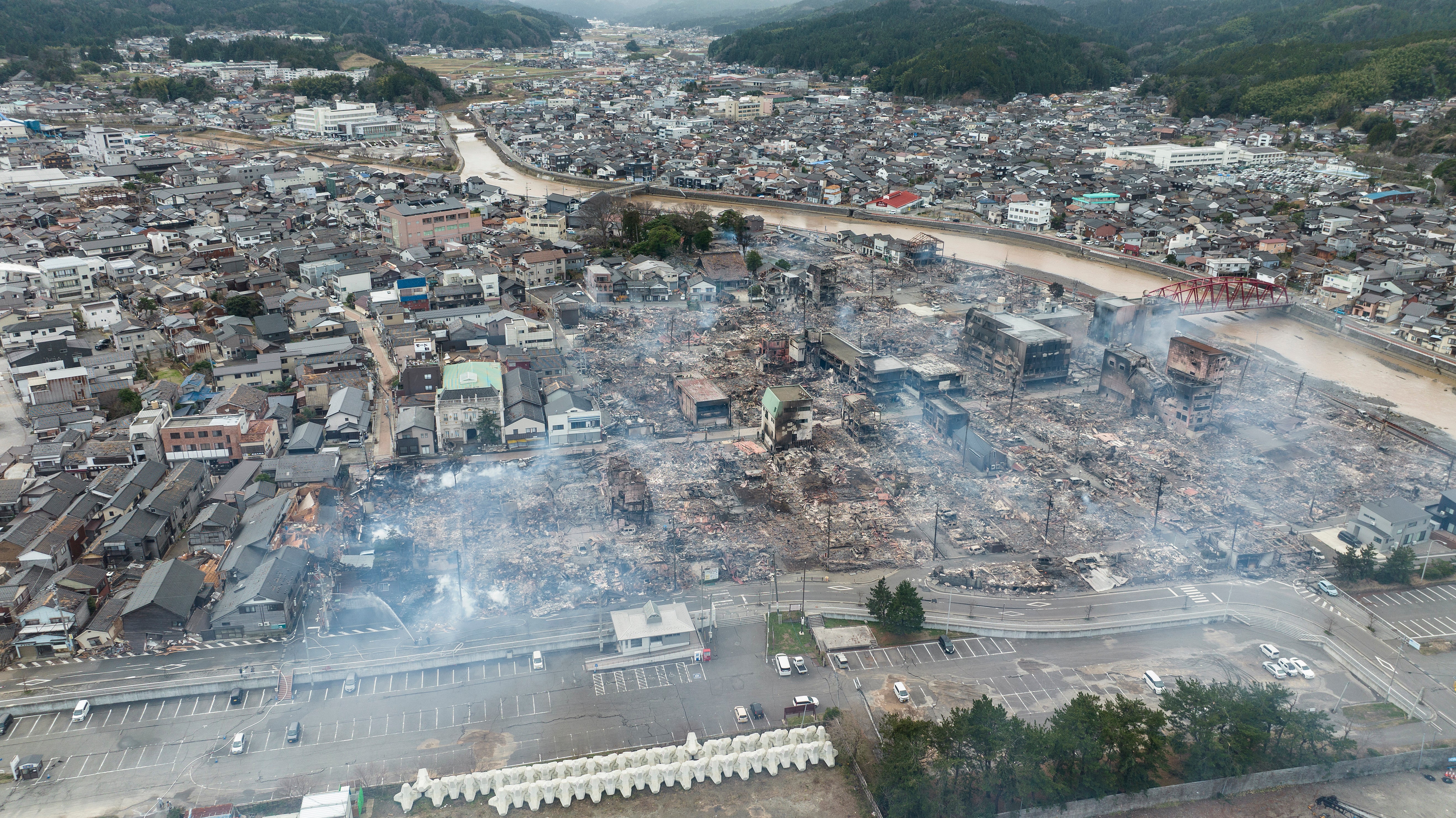 This aerial photo shows smoke rising from an area following a large fire in Wajima, Ishikawa prefecture