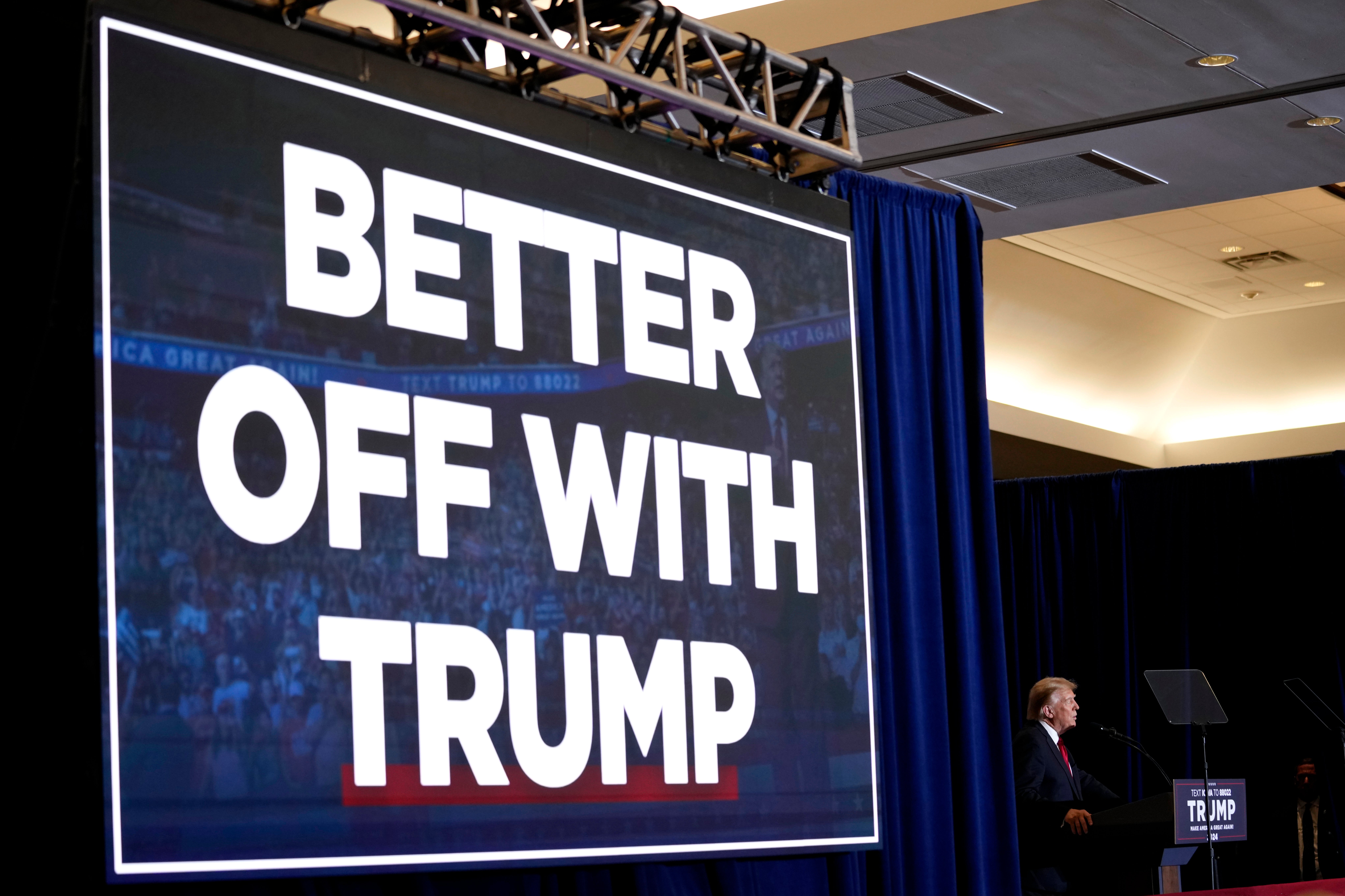 A campaign slogan hangs above Donald Trump as he speaks to supporters in Iowa on 13 December