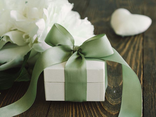<p>Bouquet of beautiful white peonies with gift boxes on wood background. </p>
