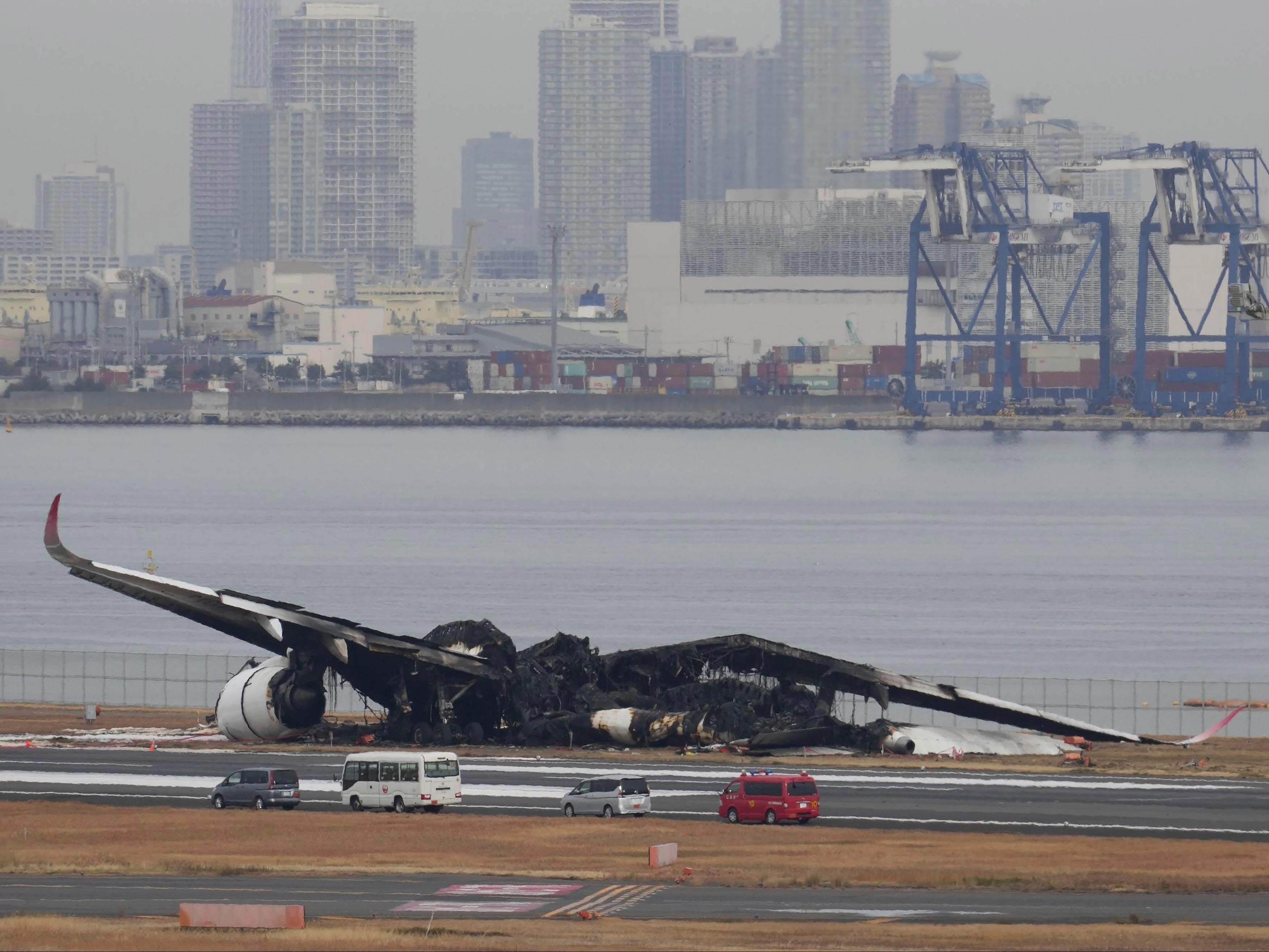 The burn-out wreckage of Japan Airlines plane is seen at Haneda airport