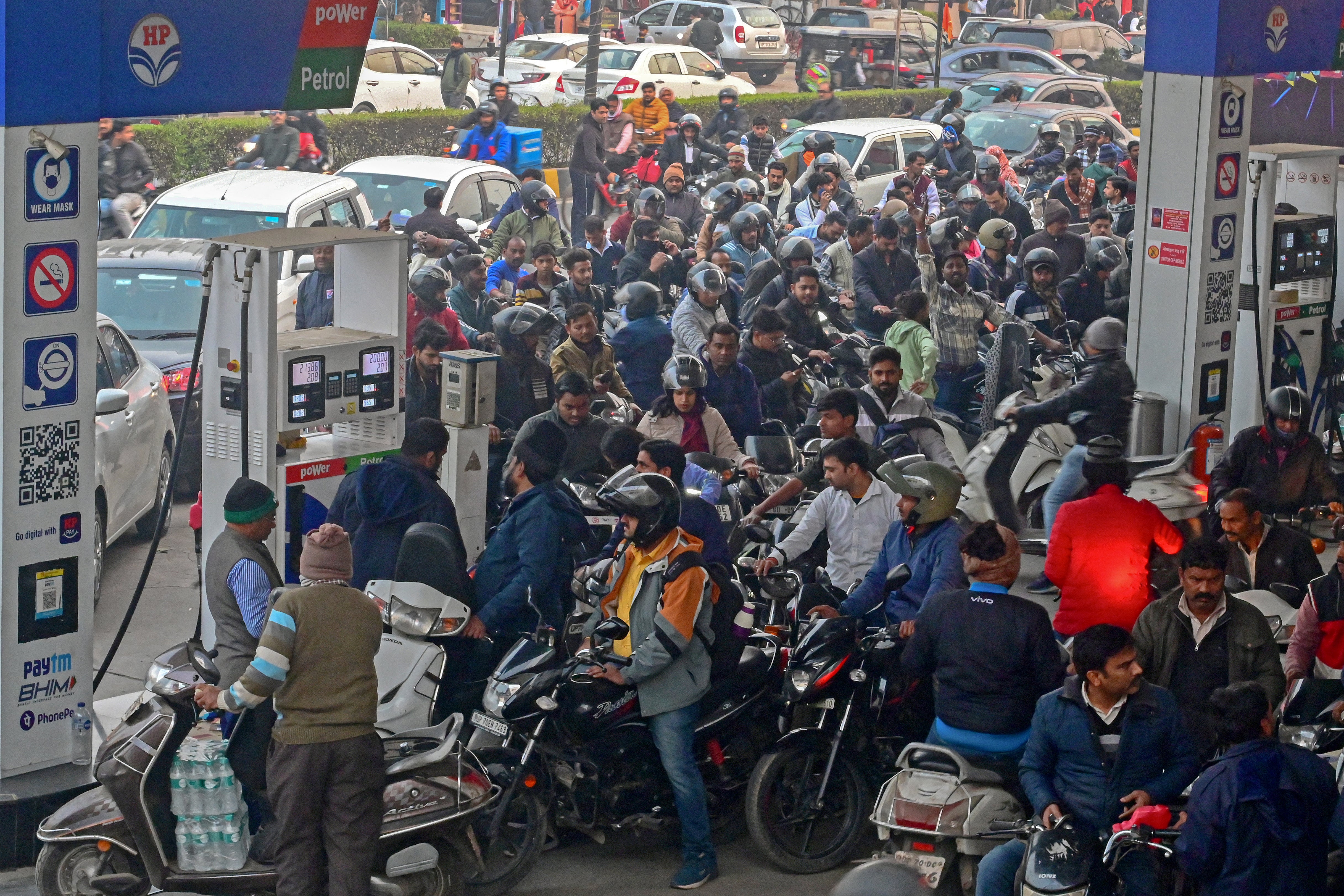 People with their vehicles wait to refill fuel tanks at a fuel station in Prayagraj, Uttar Pradesh on 2 January 2024