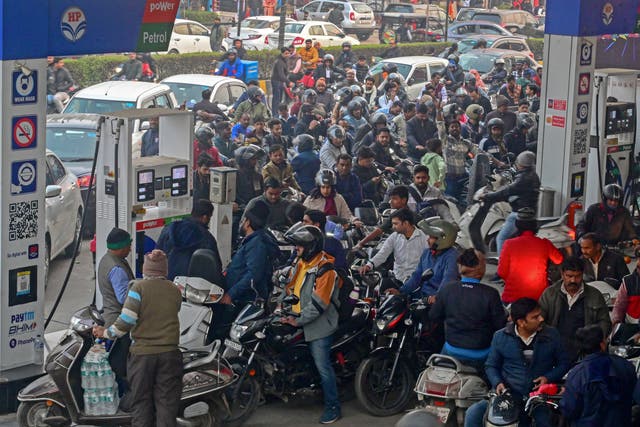 <p>People with their vehicles wait to refill fuel tanks at a fuel station in Prayagraj, Uttar Pradesh on 2 January 2024</p>