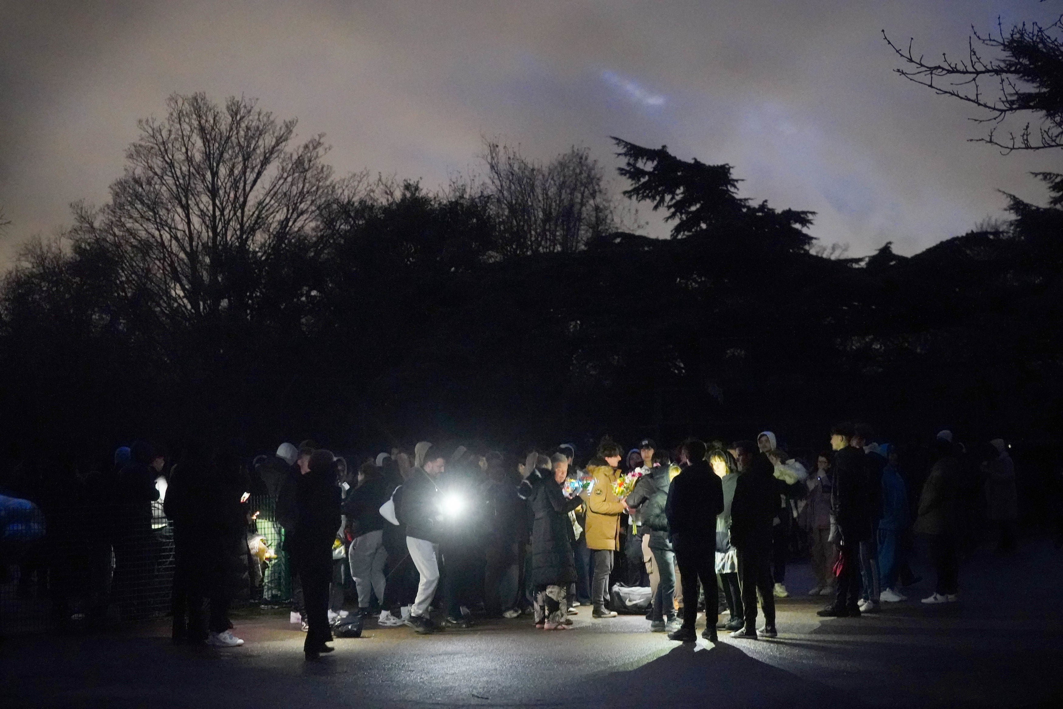 People take part in a vigil in Downhills Park for the 16-year-old