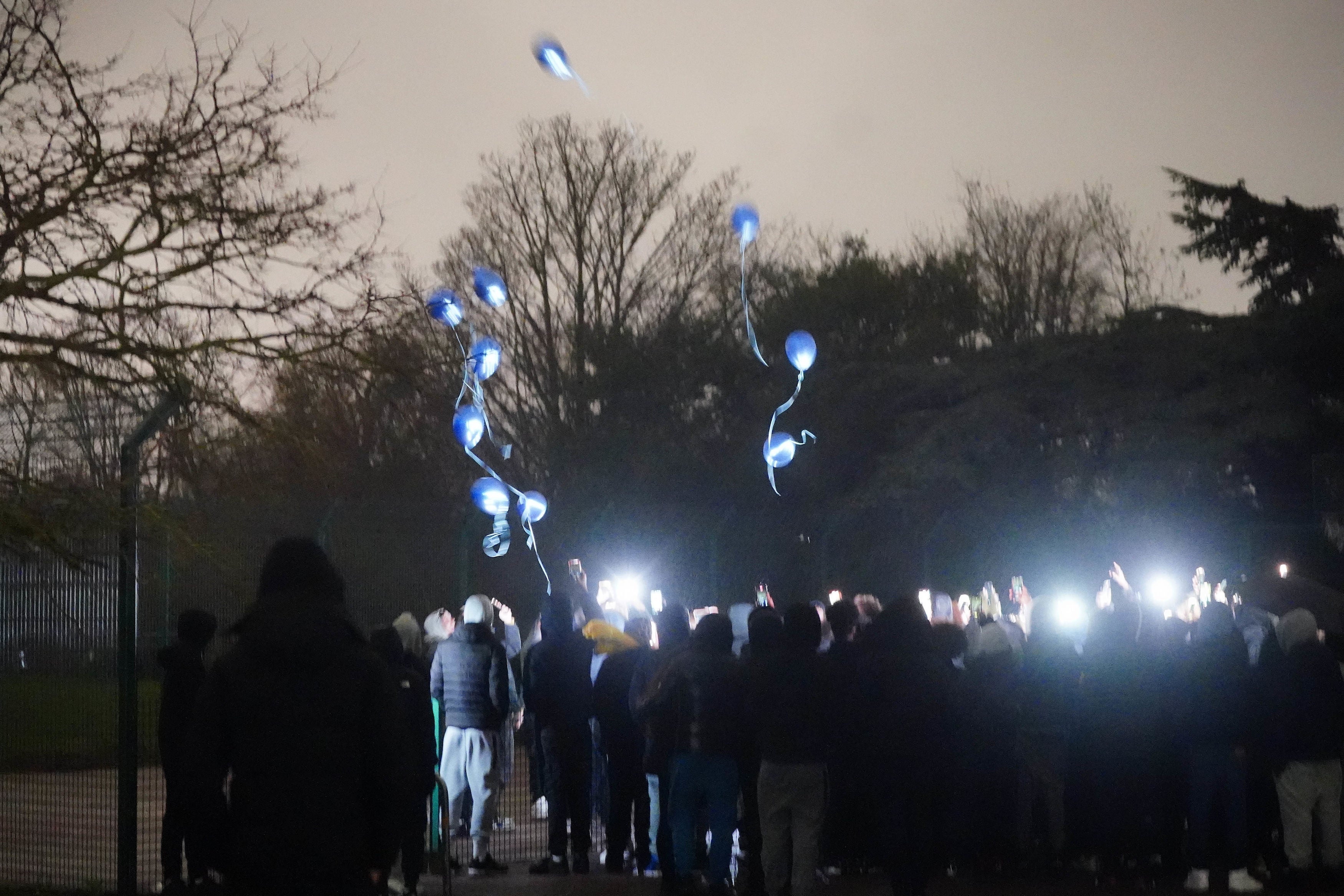 People release balloons as they take part in a vigil in Downhills Park in the West Green area of Haringey, London, for 16-year-old Harry Pitman