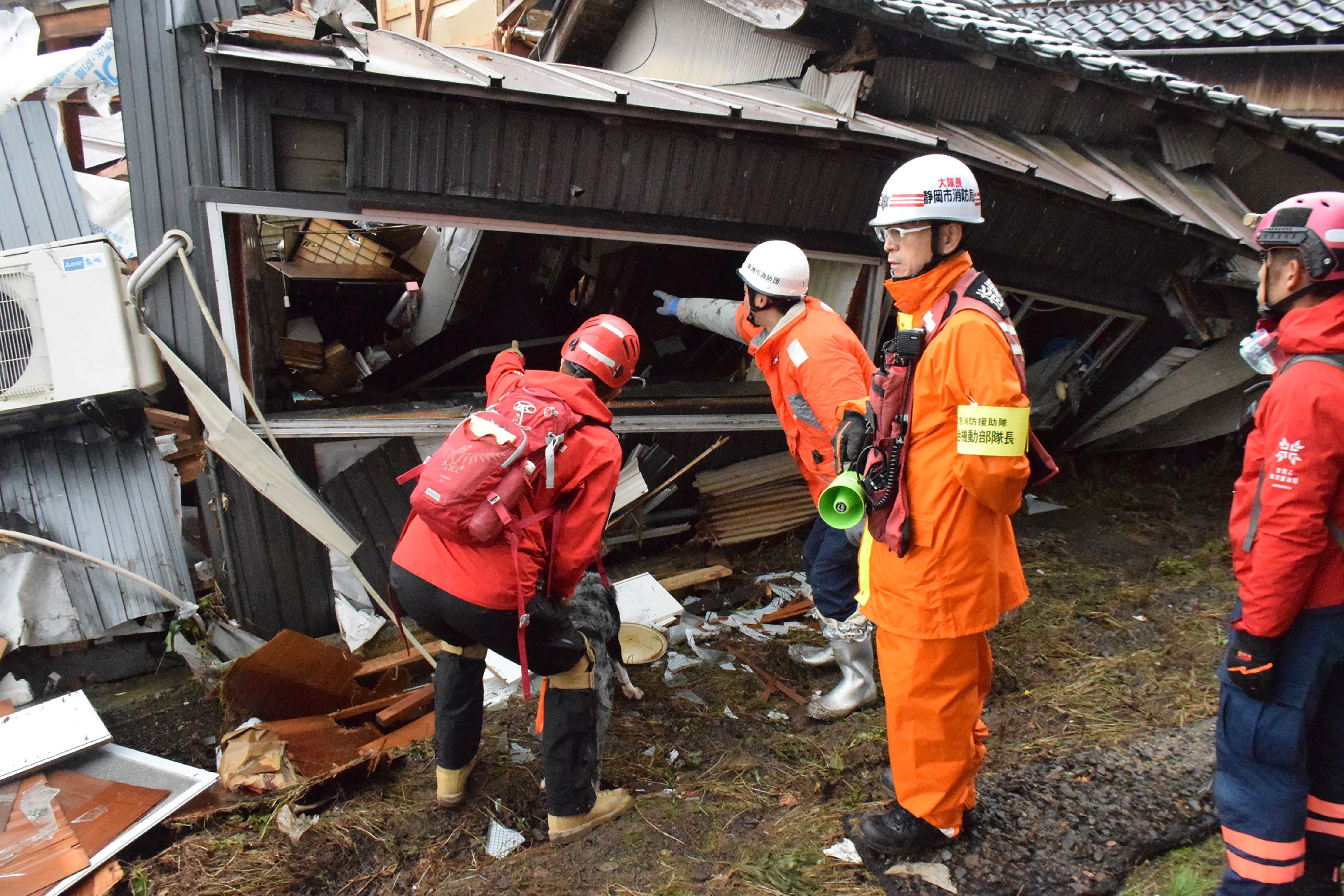 Firefighters search a collapsed house for survivors
