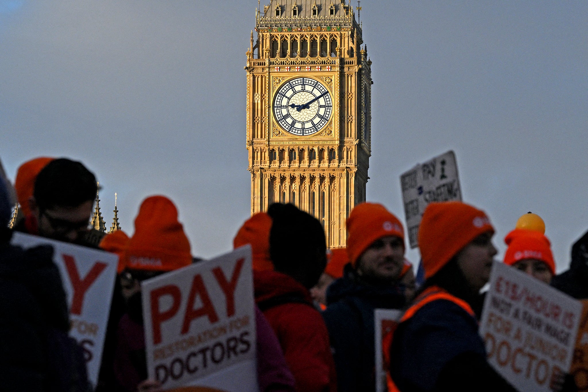 People hold placards calling for better pay, as they stand on a picket line outside St Thomas' Hospital in central London on January 3, 2024, on the first day of six days of strike action