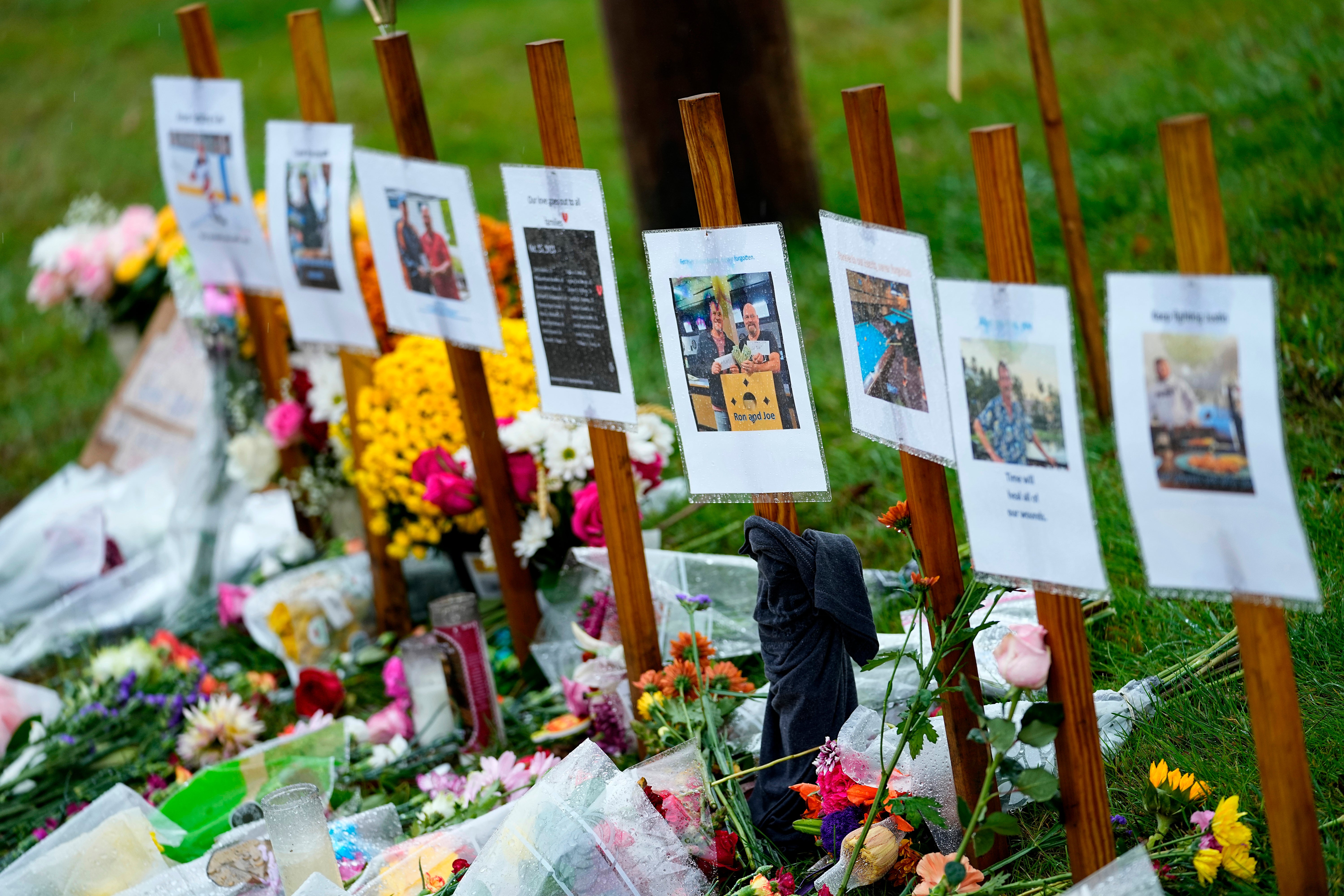 Rain soaked memorials for those who died in a mass shooting sit along the roadside by Schemengees Bar & Grille