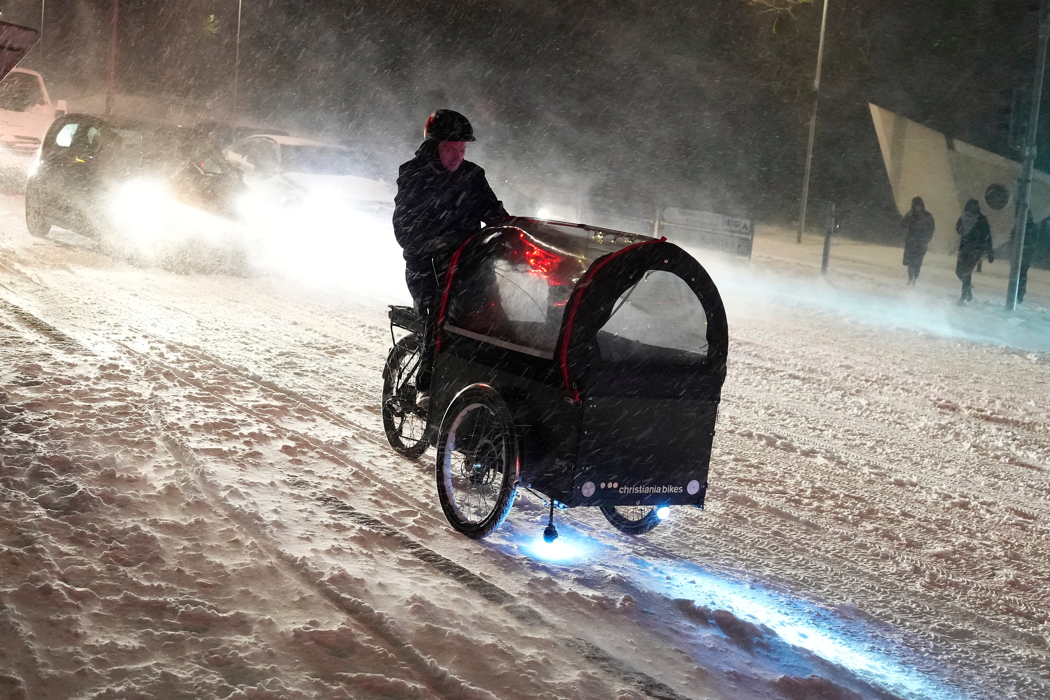 A person rides their bicycle as a blizzard hits the morning traffic in Aalborg, Denmark