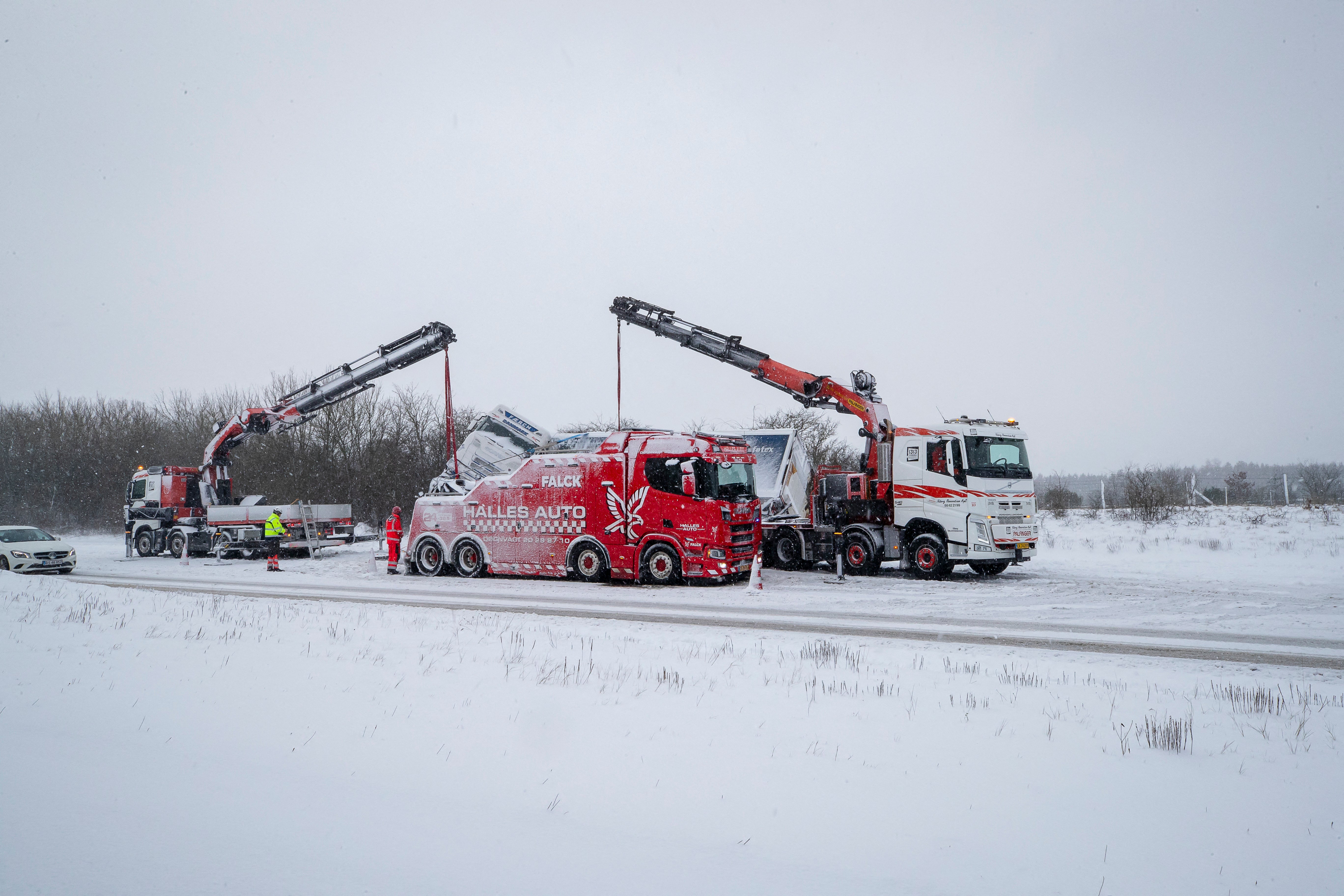 A truck is being removed from the snowy street following an accident during heavy snowfall in Viborg, central Jutland, Denmark