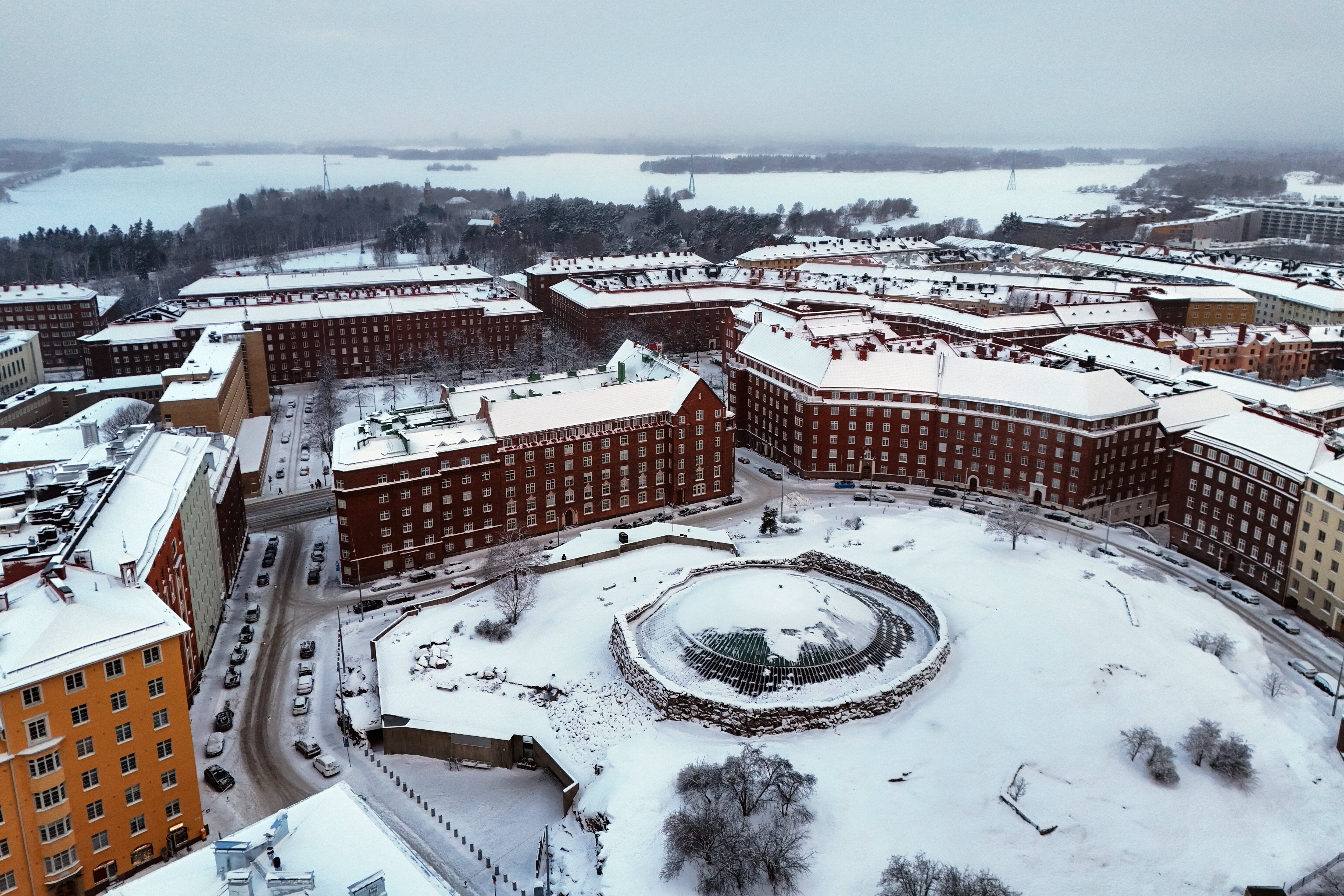 An aerial view taken on January 3, 2024 shows snow and ice in the TÃ¶Ã¶lÃ¶ area with the Temppeliaukio Church (front C) and Lapinlahti Bay in the Finnish capital Helsinki