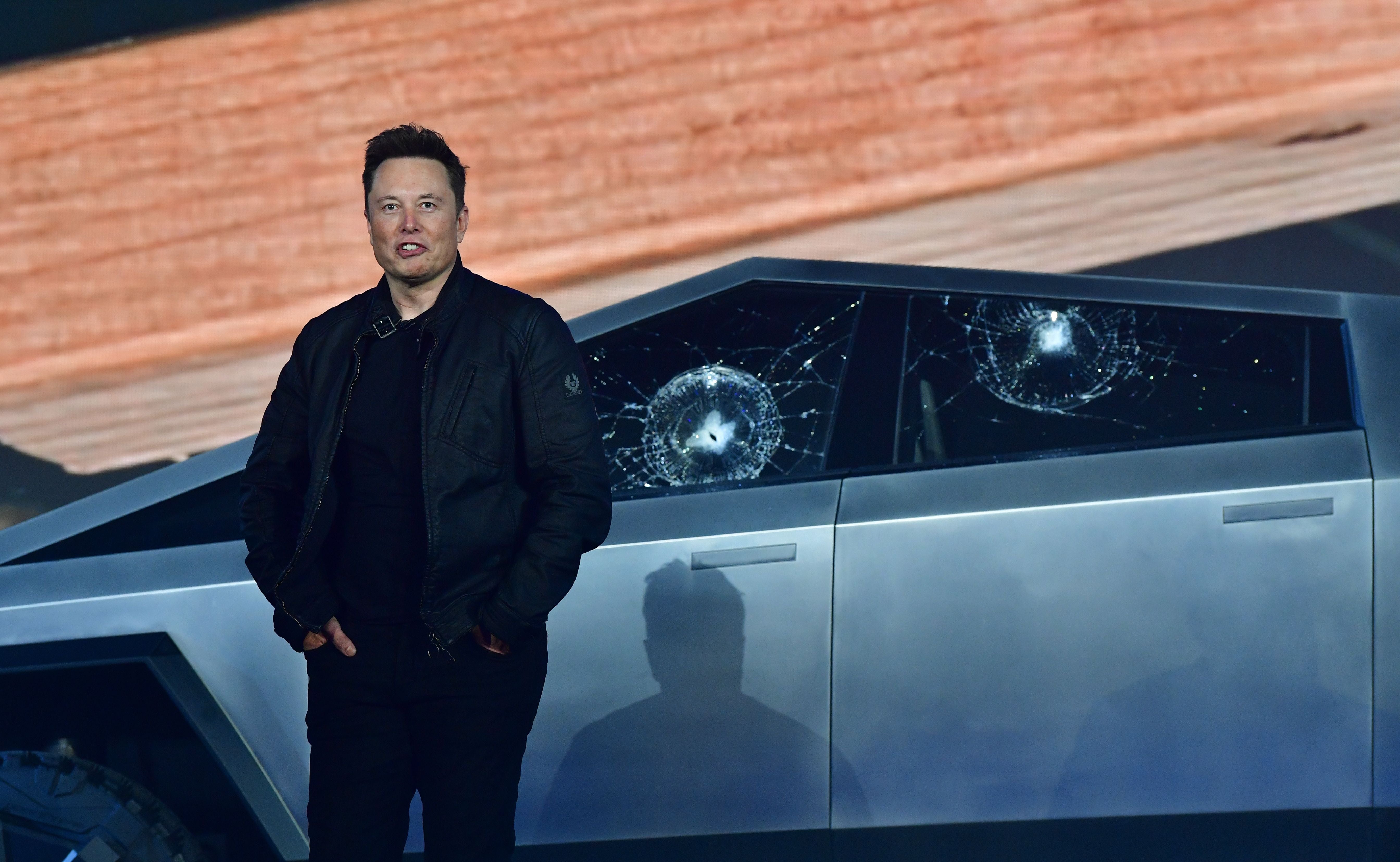 Tesla co-founder and CEO Elon Musk stands in front of the shattered windows of the newly unveiled all-electric battery-powered Tesla’s Cybertruck at Tesla Design Center in Hawthorne, California on November 21, 2019