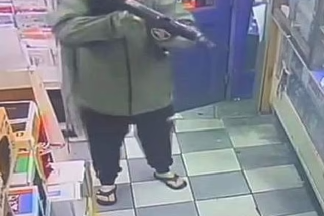 <p>CCTV from the newsagent appears to show a hooded man carrying a large firearm </p>